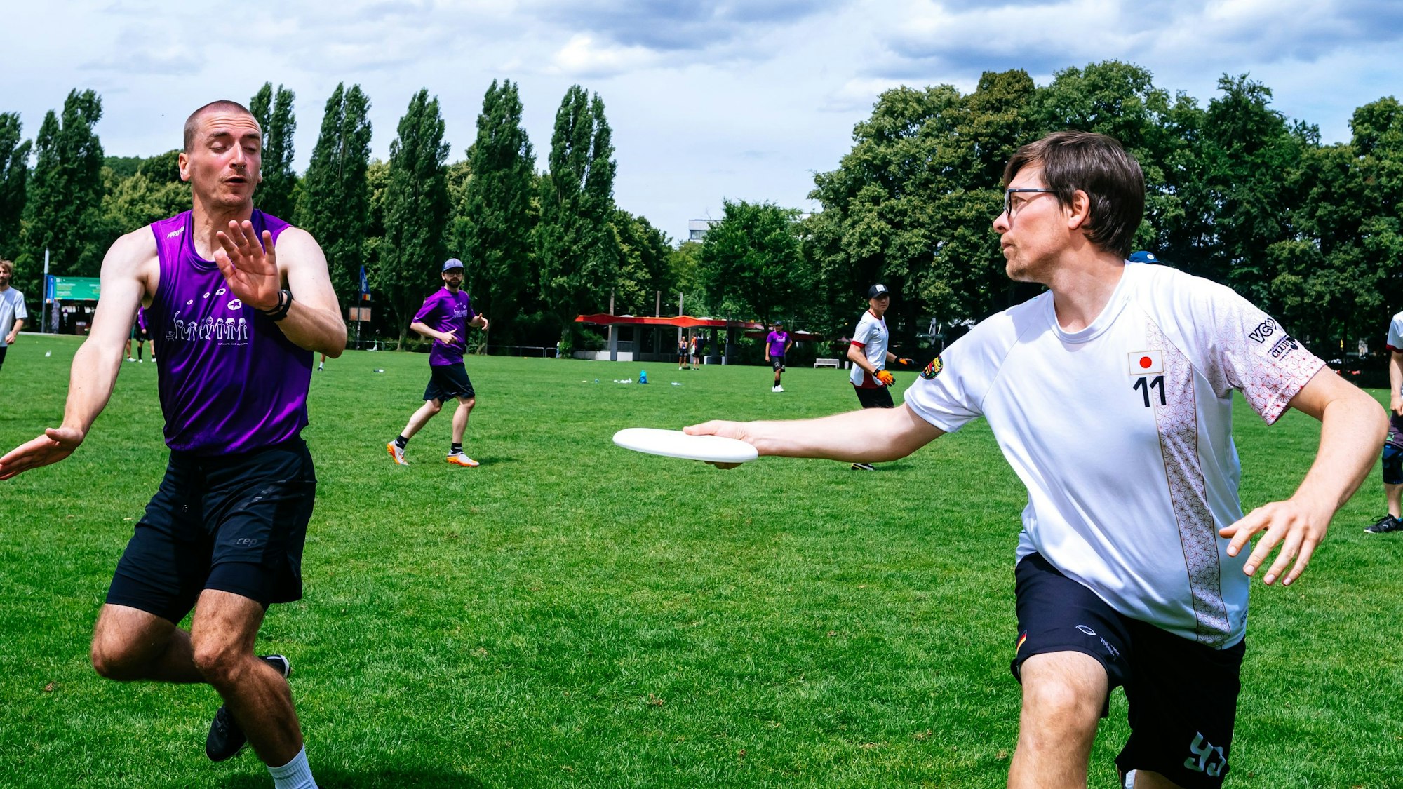 Zwei Spieler werfen sich eine Frisbee zu.