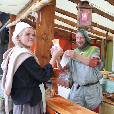 Mittelaltermarkt Denklingen, Kundin Merle kauft ein gefülltes Fladenbrot bei Martin Edelmann.