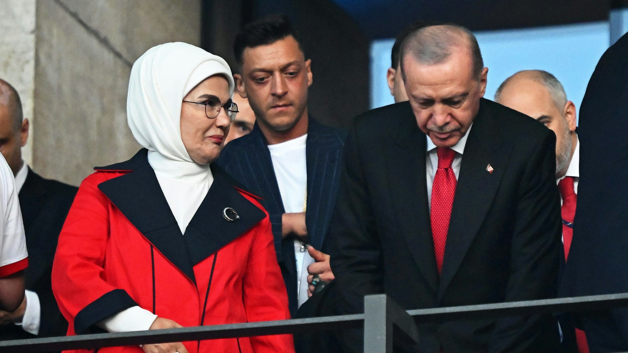 Mesut Özil (M), ehemaliger deutscher Nationalspieler, steht hinter Recep Tayyip Erdogan (r), Präsident der Türkei, und seiner Frau Emine Erdogan (l) vor dem Spiel auf der Tribüne.