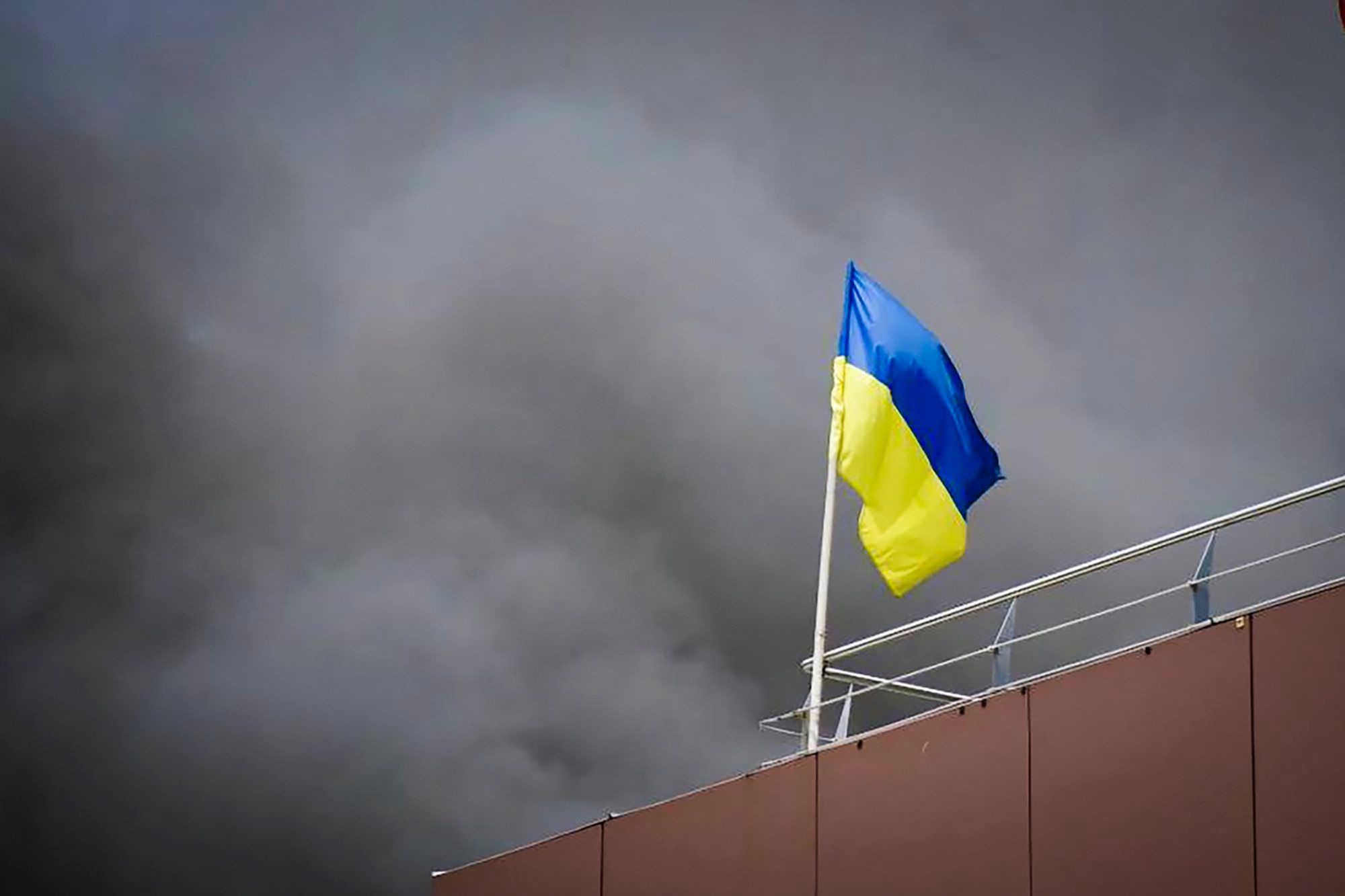 Ukraine, Dnipro: Auf diesem von der Regionalverwaltung Dnipro veröffentlichten Foto weht die ukrainische Flagge, während nach einem russischen Raketenangriff Rauch aufsteigt.