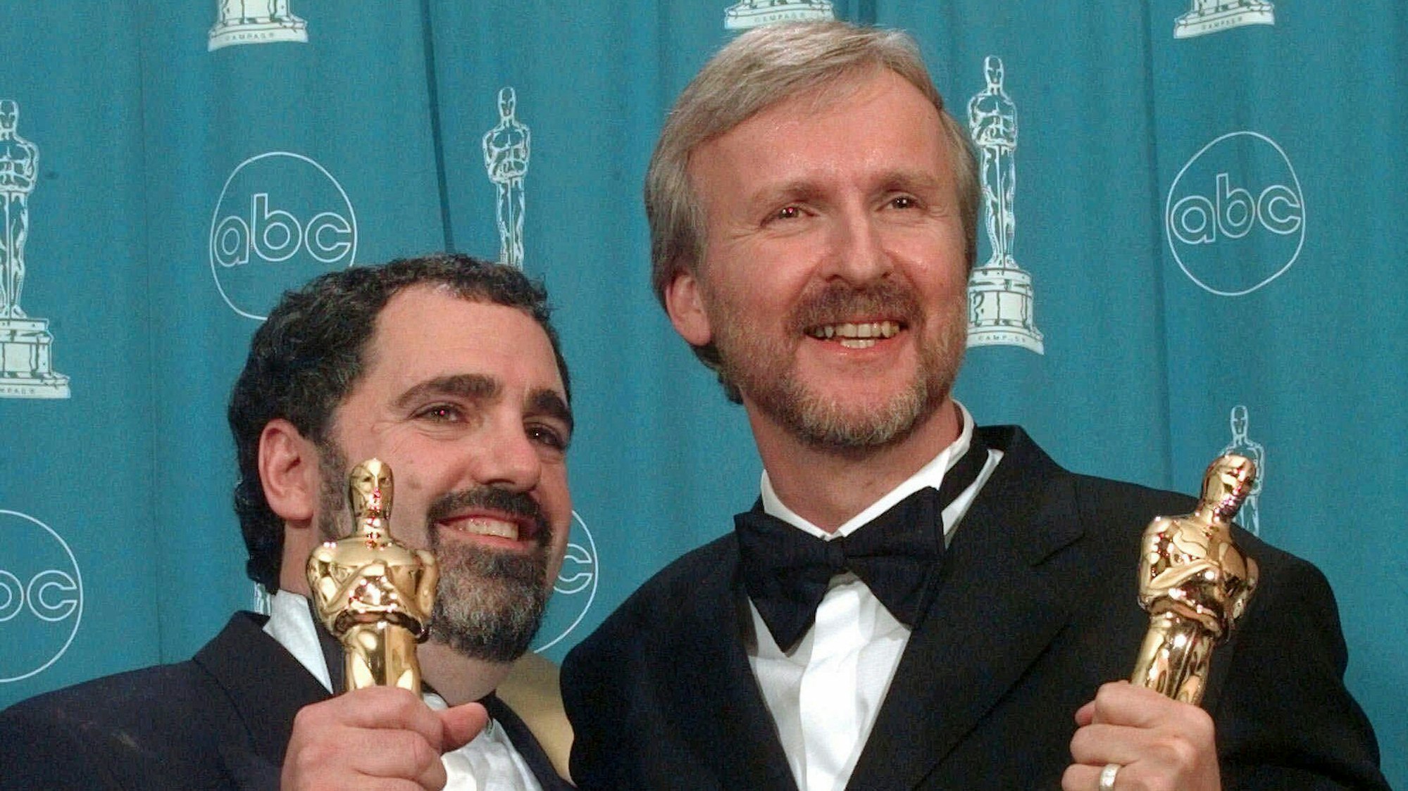 James Cameron und Jon Landau halten fröhlich ihre Oscars in die Kamera.