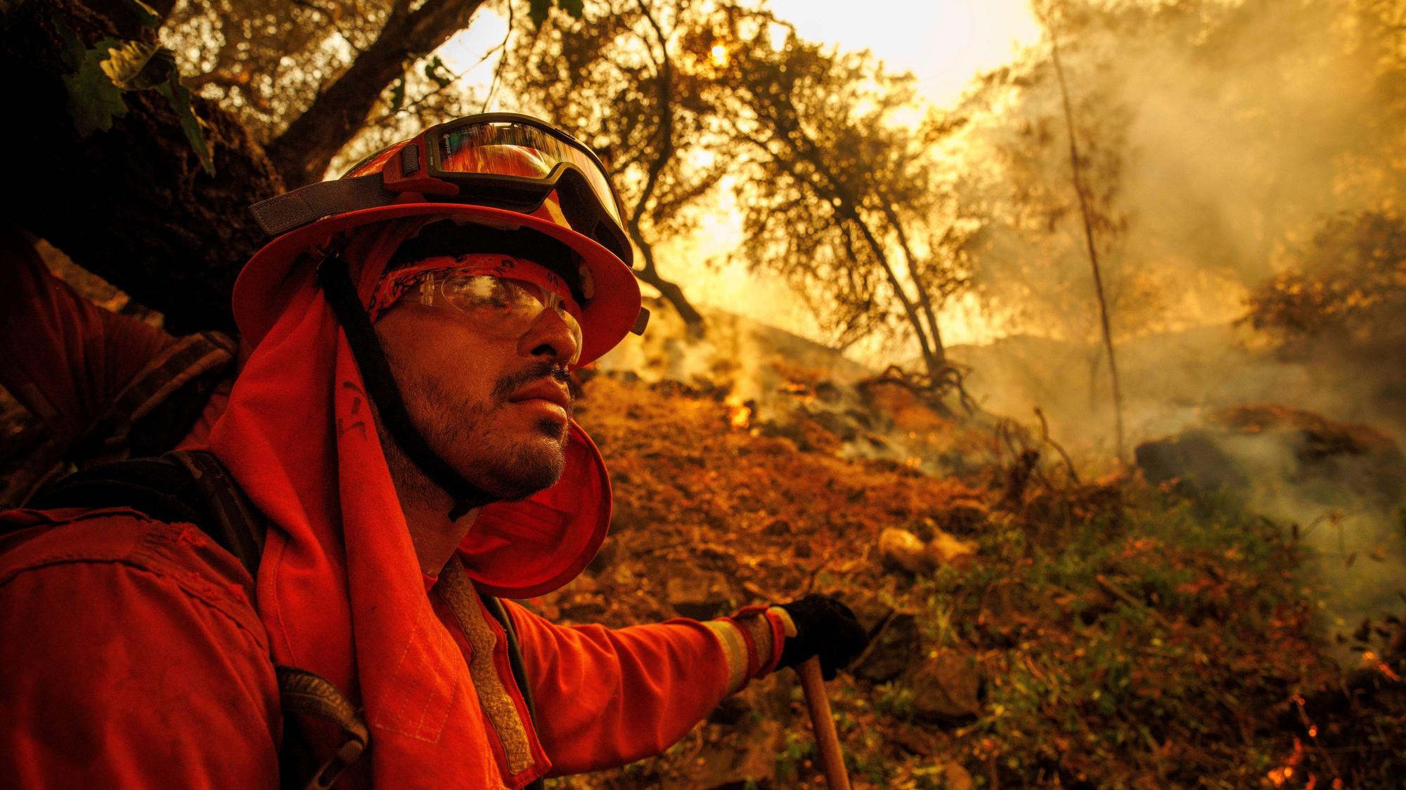 02.07.2024, USA, Oroville: Ein Feuerwehrmann gräbt eine Feuerschneise, während das Thompson-Feuer brennt. Foto: Ethan Swope/AP/dpa +++ dpa-Bildfunk +++