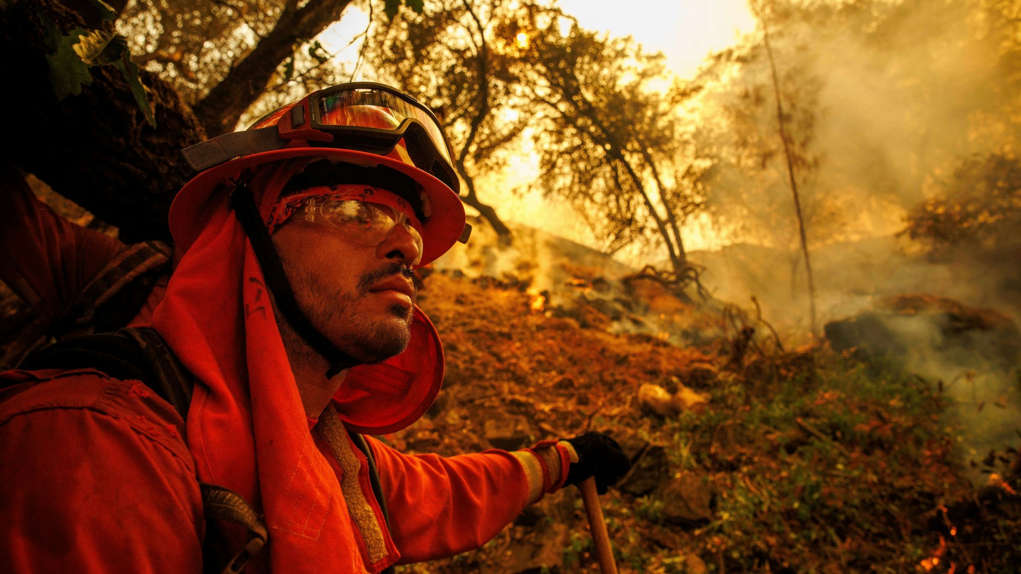 02.07.2024, USA, Oroville: Ein Feuerwehrmann gräbt eine Feuerschneise, während das Thompson-Feuer brennt. Foto: Ethan Swope/AP/dpa +++ dpa-Bildfunk +++