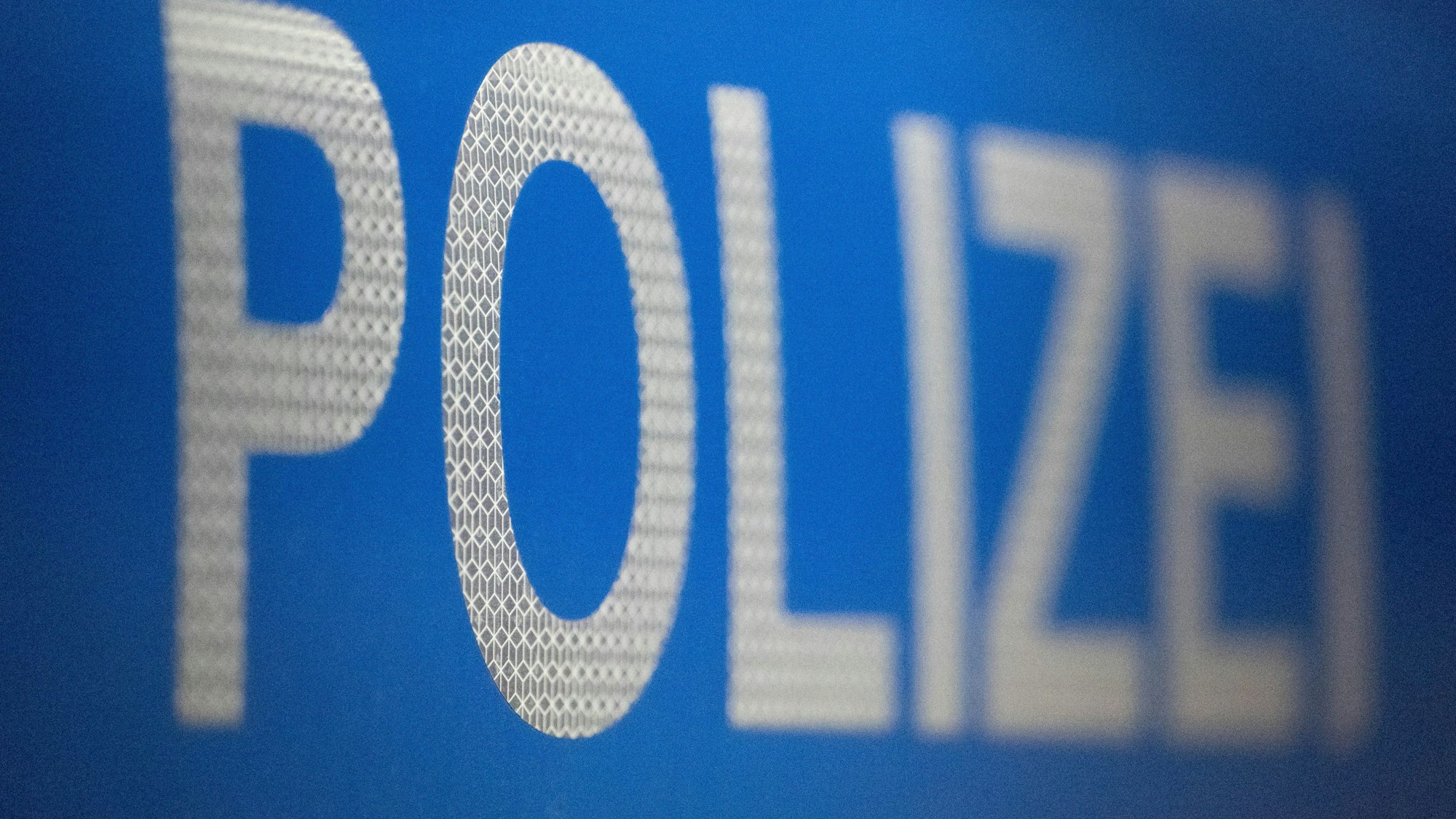 Das Bild zeigt den Schriftzug Polizei auf einem Streifenwagen.