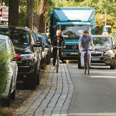 Die viel befahrene Frankfurter Straße in der Hennefer Innenstadt mit Autos, Lkw und zwei Radlern.