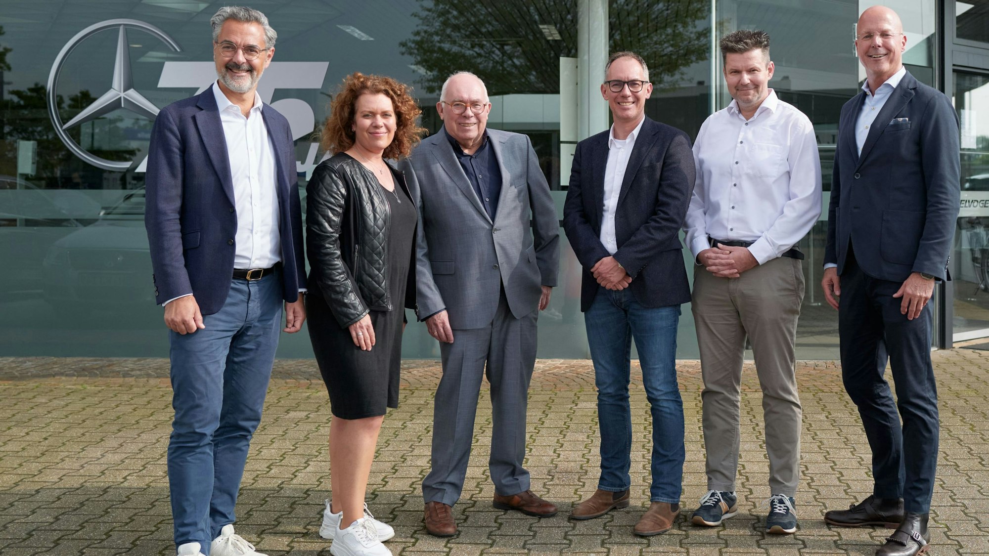 Mehrere Männer und eine Frau haben sich vor dem Autohaus Spielvogel in Bergheim zum Gruppenfoto aufgestellt.