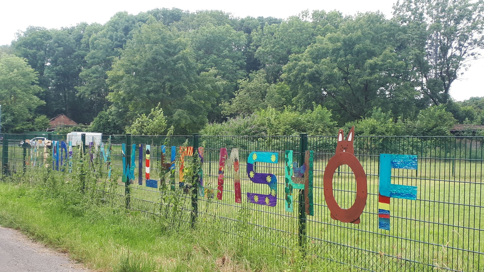 Blick auf den bunten Zaun des Wilhelmshofs im Äußeren Grüngürtel.