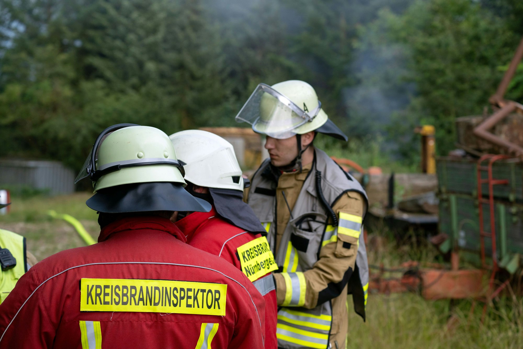 dpatopbilder - 07.07.2024, Bayern, Altdorf Bei Nürnberg: Einsatzkräfte der Feuerwehr stehen auf einem Gartengrundstück, aus dem Qualm aufsteigt. Nach stundenlanger Fahndung nach einem Bewaffneten in Altdorf bei Nürnberg hat die Polizei die Leiche eines Mannes gefunden. Foto: Pia Bayer/dpa +++ dpa-Bildfunk +++