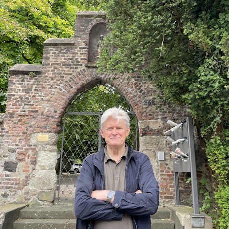 Wilhelm Jüllich steht vor dem Eingangstor der alten Pfarrkirche Alt. St. Pankratius in Köln-Worringen.