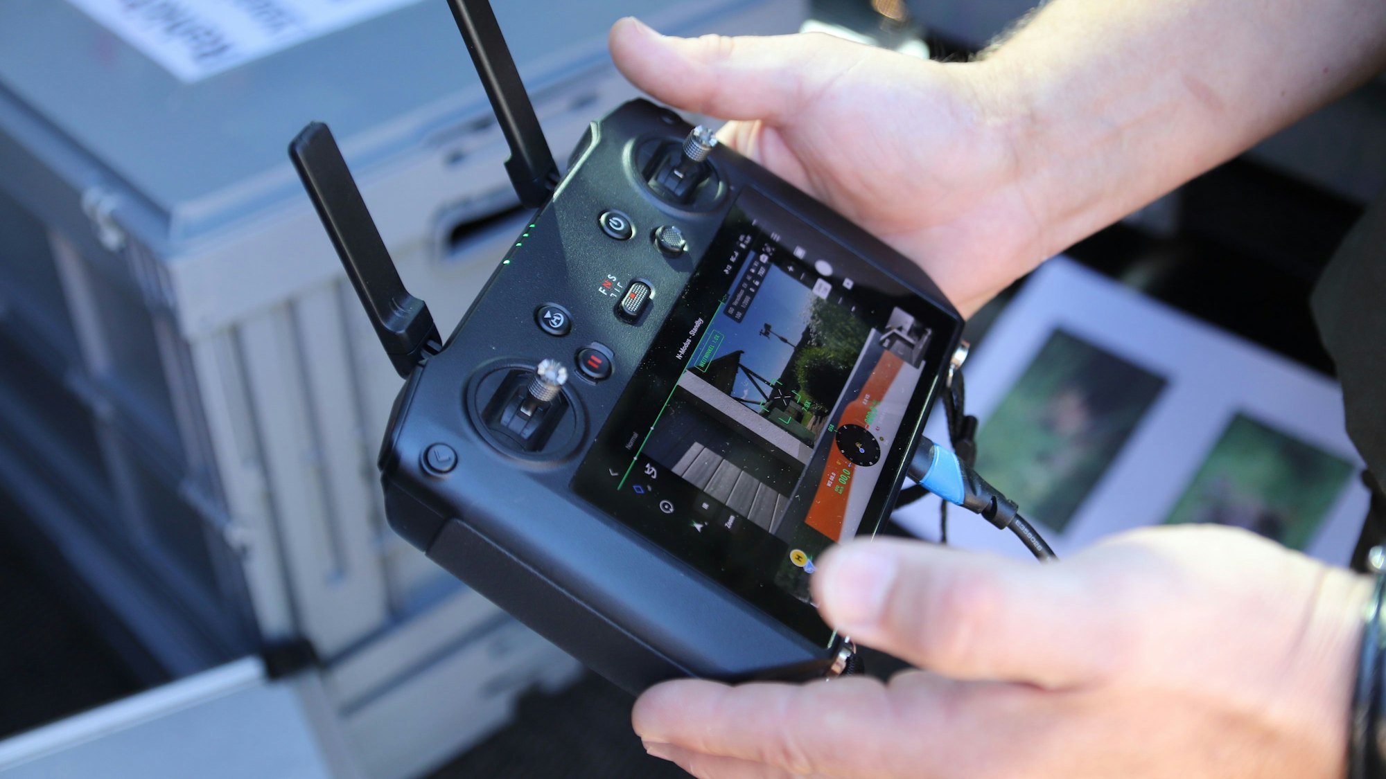 Ein Drohnenpilot hält eine Fernbedienung in der Hand.