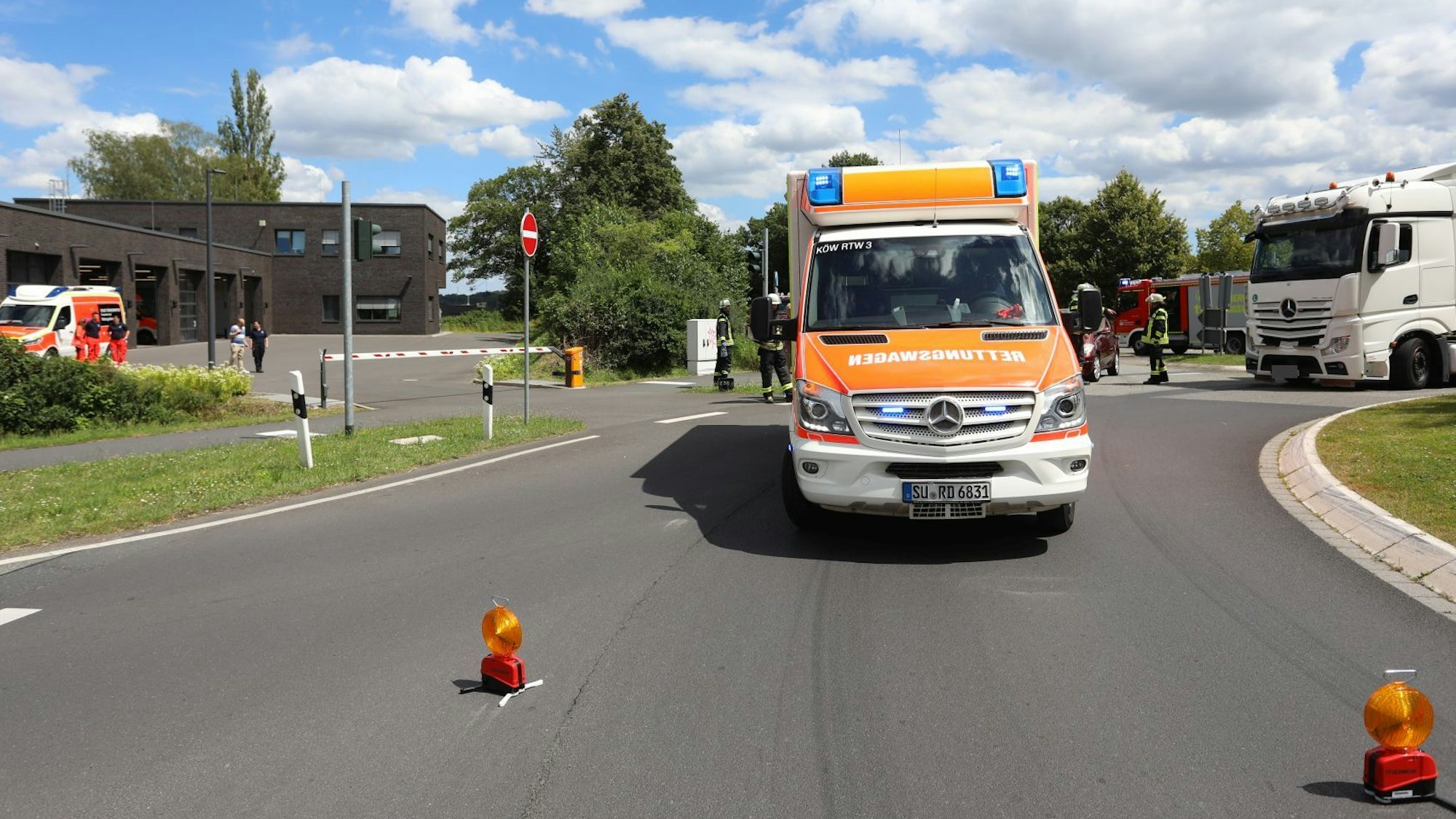 Ein Rettungswagen steht auf der Straße im Kreisverkehr, im Hintergrund ist die Rettungswache Oberpleis zu sehen.