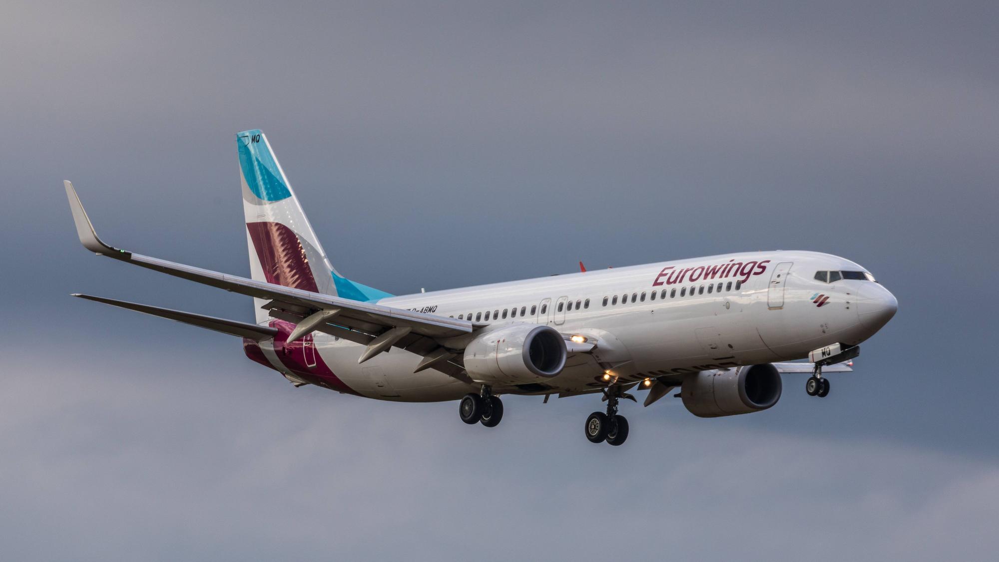Eine Boeing 737 der deutschen Fluggesellschaft Eurowings im Landeanflug vor einem Unwetter. Am Flugzeug leuchten mehrere Warnleuchten. (Symbolbild)