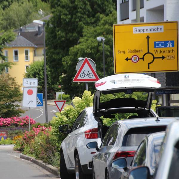 Umleitungsschild mit rotem Punkt am Kreisverkehr an der Overather Pfarrkirche St. Walburga.