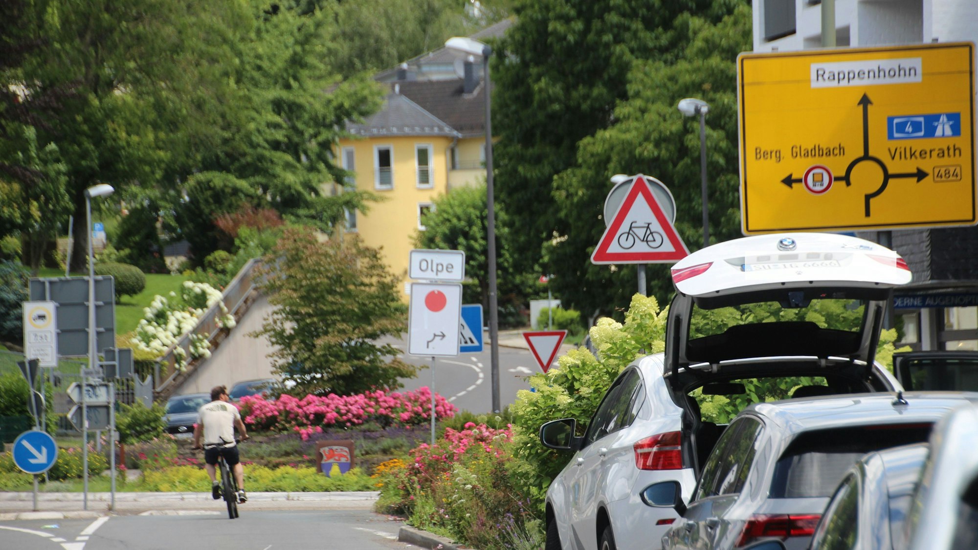 Umleitungsschild mit rotem Punkt am Kreisverkehr an der Overather Pfarrkirche St. Walburga.