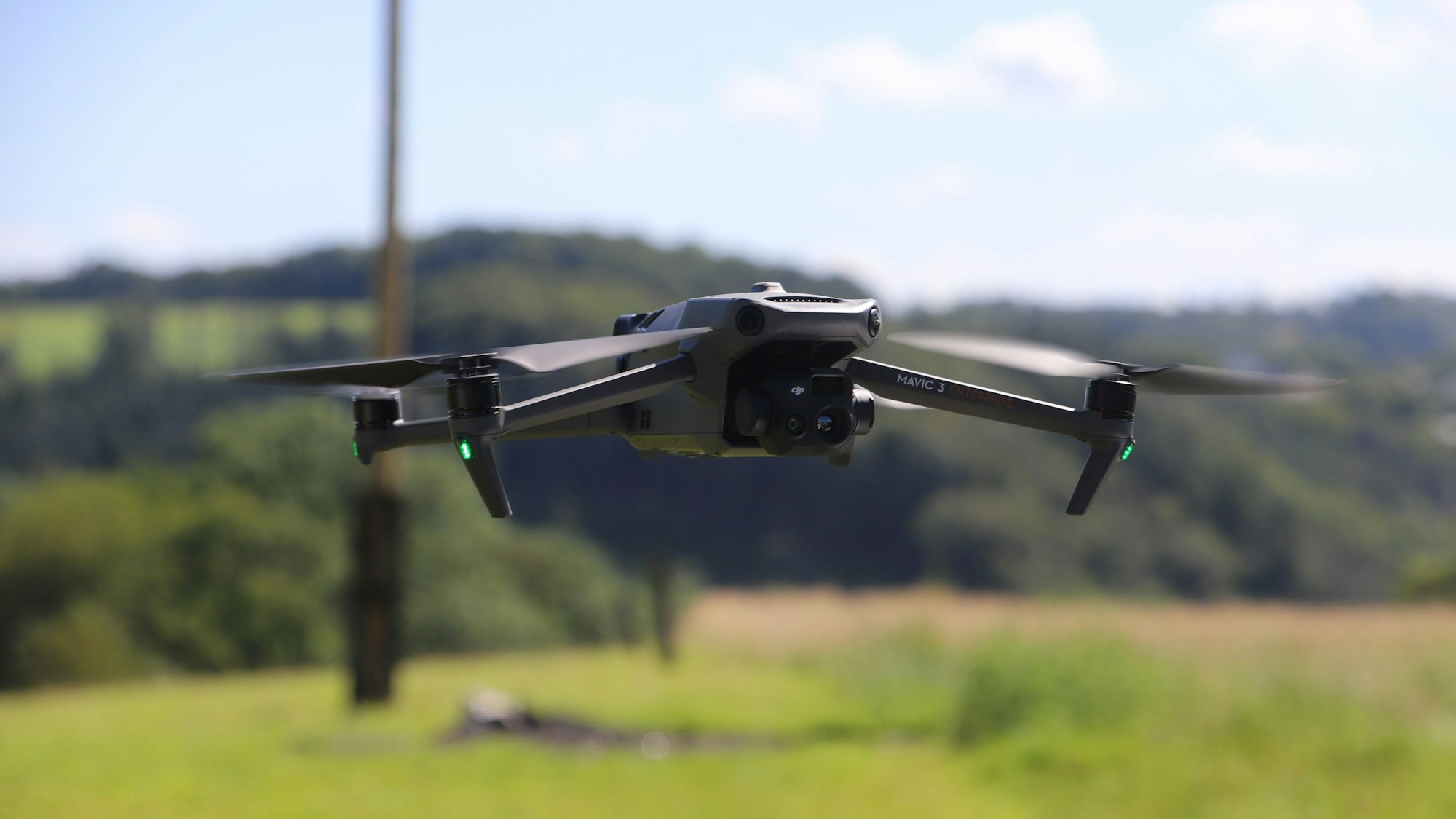 Eine Drohne schwebt gut einen Meter über dem Boden auf den Betrachter zu.