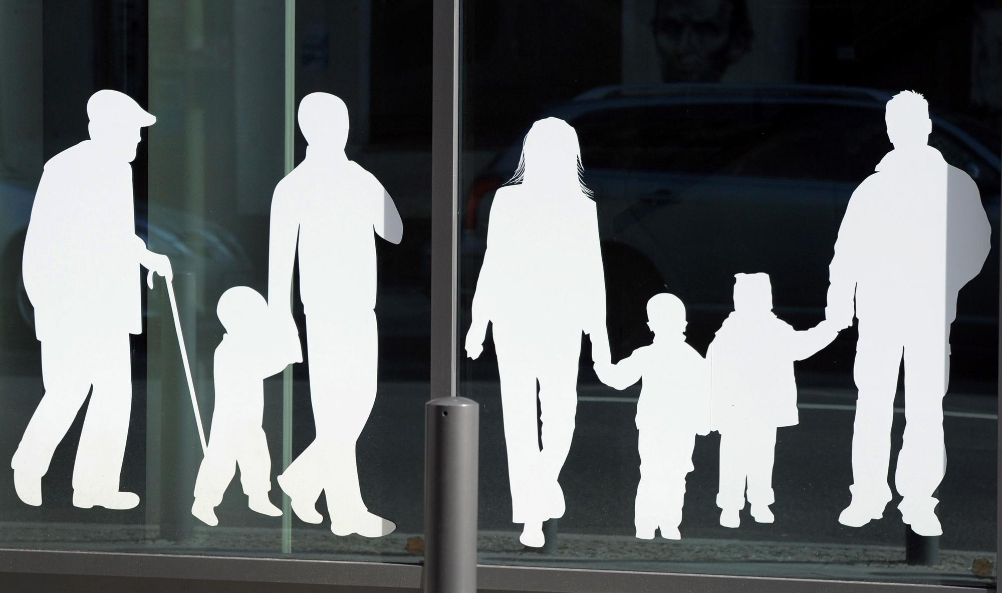 ARCHIV - ILLUSTRATION - Figuren von Menschen in verschiedenem Alter sind am am 09.03.2012 an dem Gebäude des Bundesministeriums für Familie, Senioren, Frauen und Jugend in Berlin in der Glinkastraße auf eine Scheibe aufgeklebt.