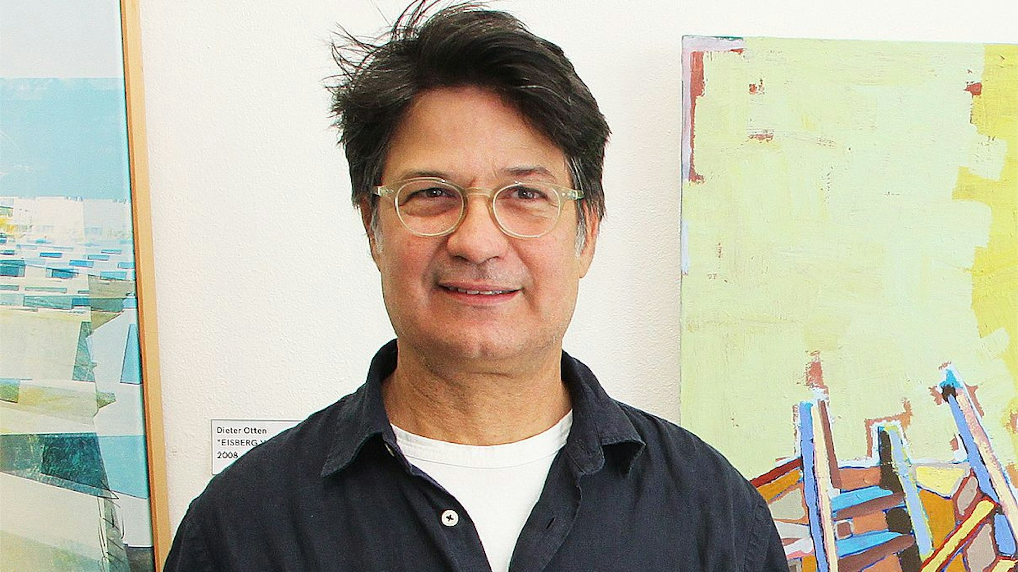 Antonio Nunez steht vor zwei Bildern.