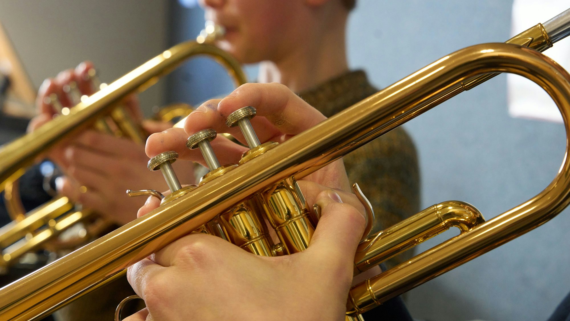 Zwei Jungen spielen im Unterricht an einer Musikschule Trompete.