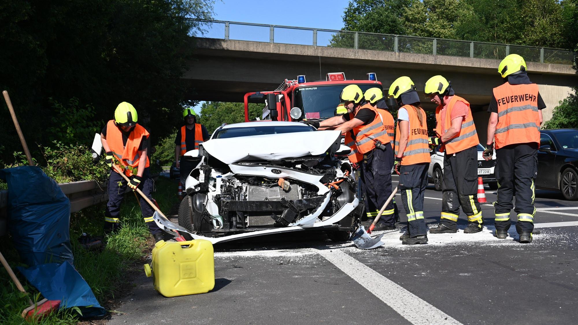 Das Bild zeigt mehrere Einsatzkräfte der Feuerwehr an einem verunfallten Wagen.