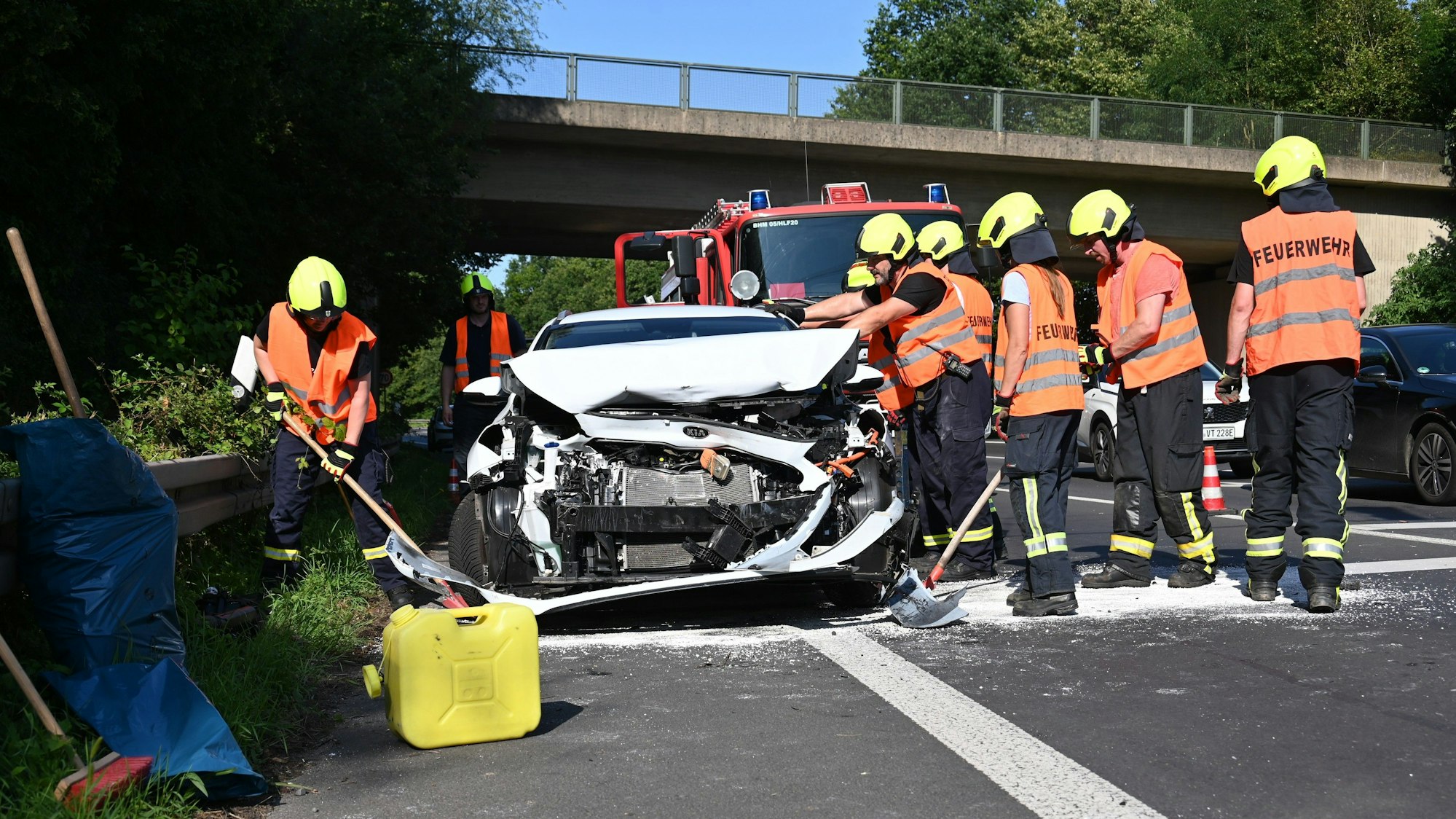 Das Bild zeigt mehrere Einsatzkräfte der Feuerwehr an einem verunfallten Wagen.
