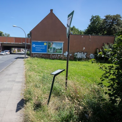Ein Gehweg trennt die Hundefreilauffläche von der Waldstraße in Porz-Urbach.