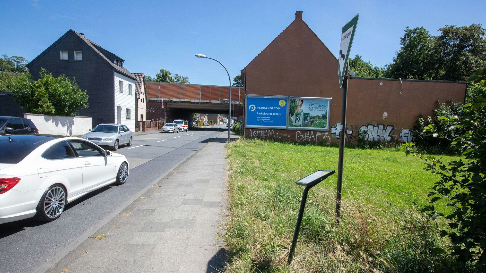 Ein Gehweg trennt die Hundefreilauffläche von der Waldstraße in Porz-Urbach.