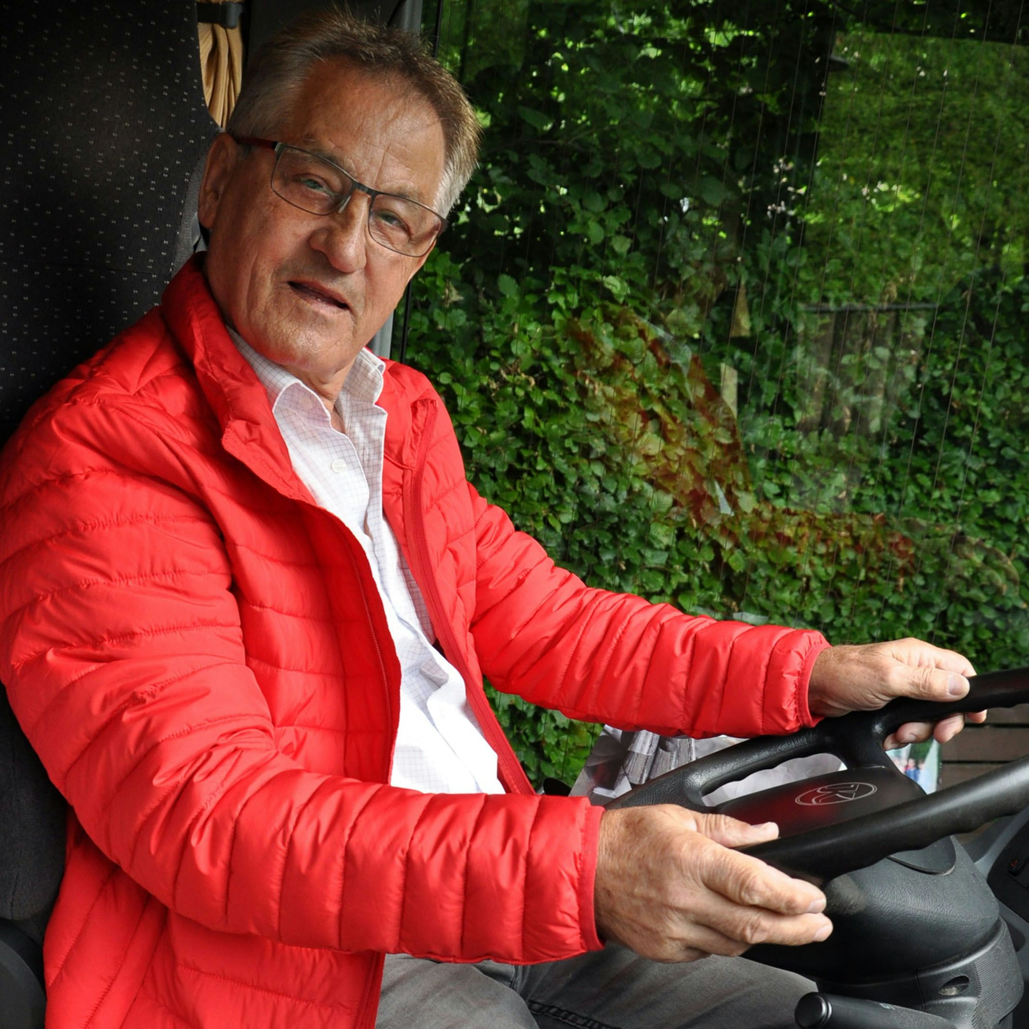 Borislav Radovic trägt eine rote Jacke und sitzt am Steuer seines Busses.