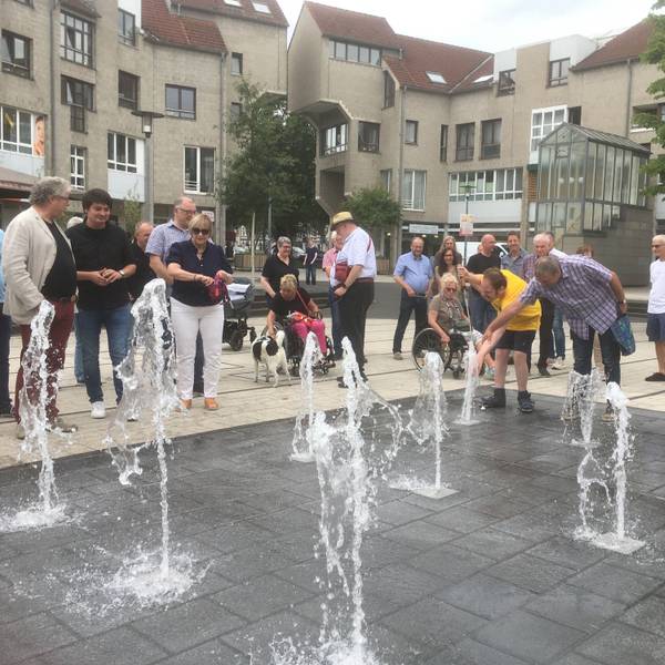 Aus mehreren Löchern im Marktplatzboden sprudeln Wasserfontänen hoch.