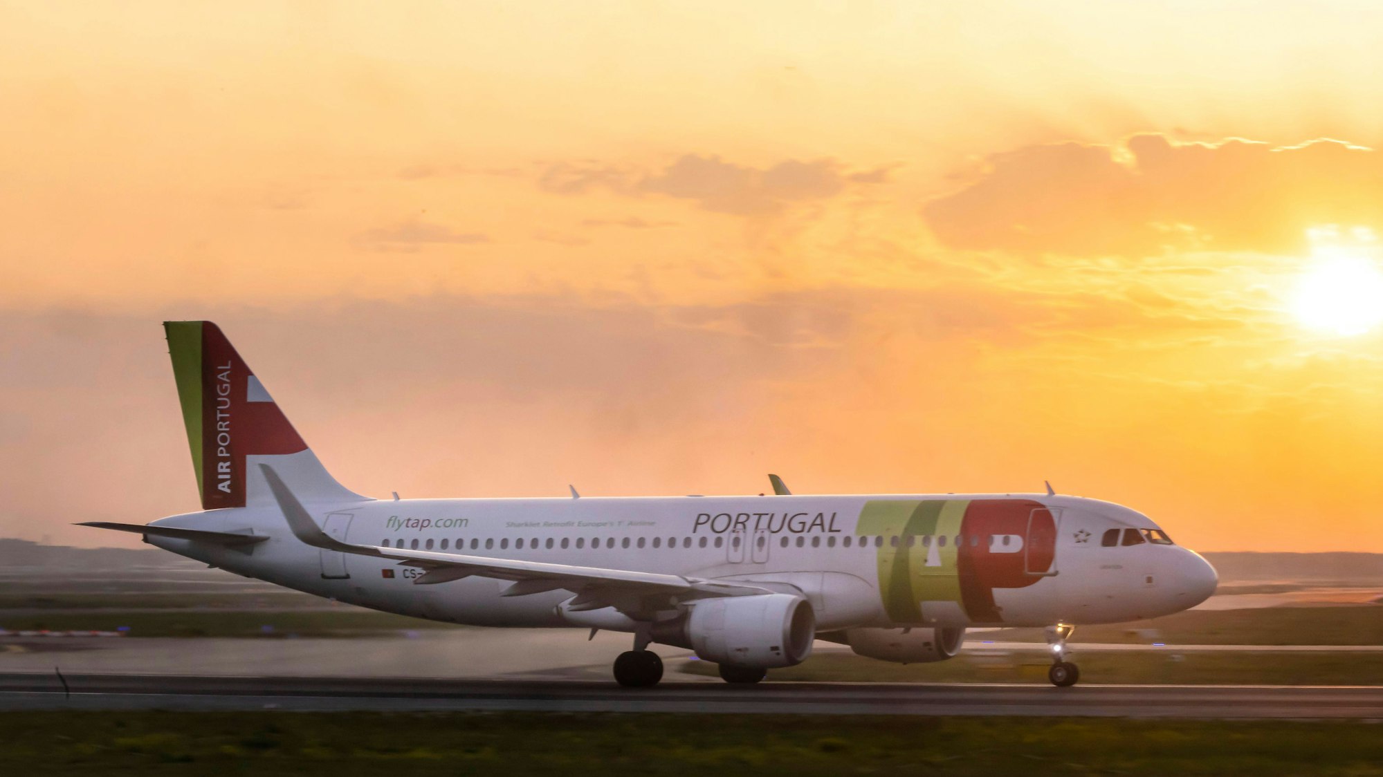 Ein Airbus A320 der portugiesischen Fluggesellschaft TAP kurz nach der Landung vor einem Sonnenuntergang. (Symbolbild)