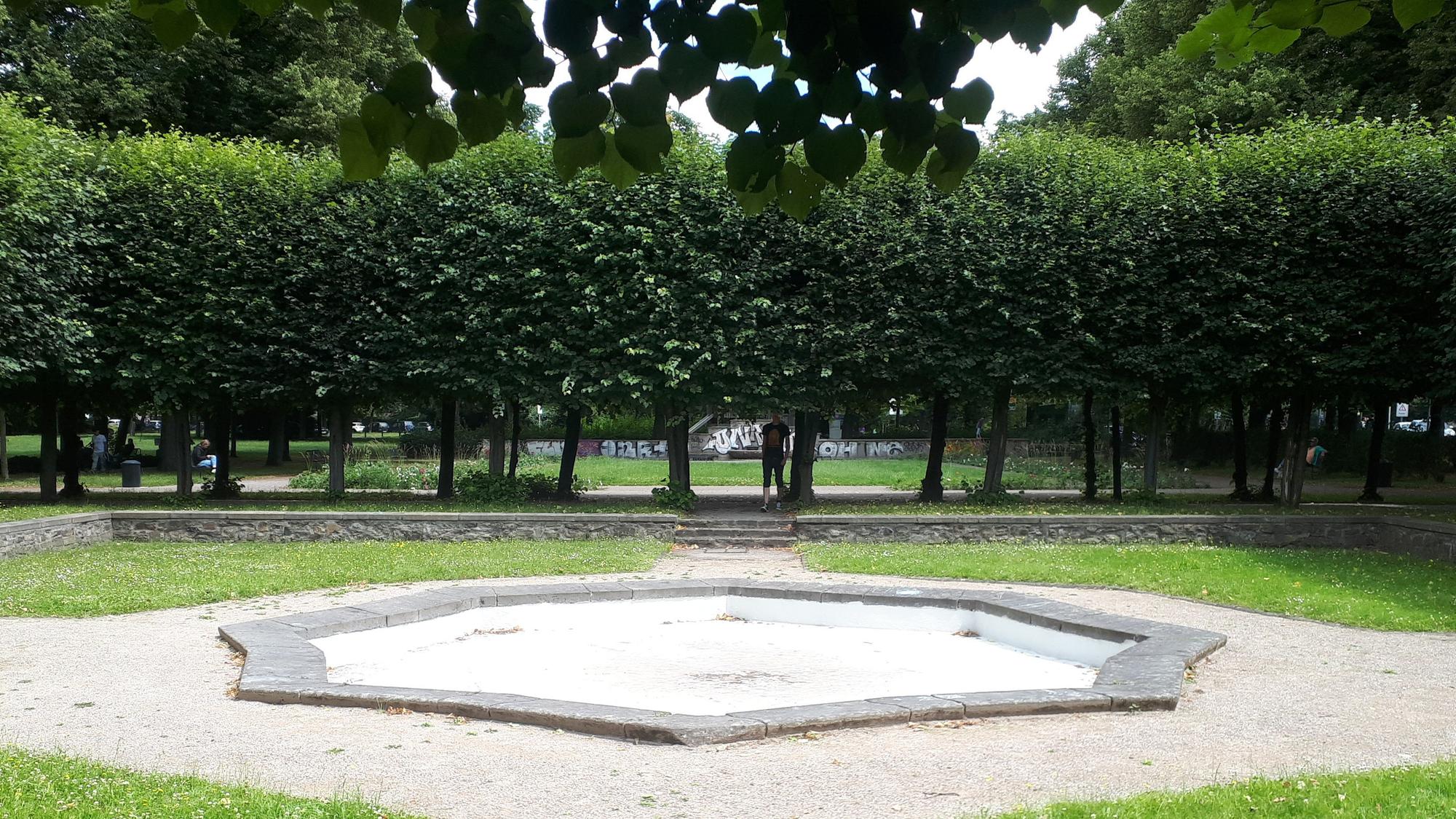 Das Brunnenbecken und die umlaufende Baumreihe an der Nippeser Alhambra.