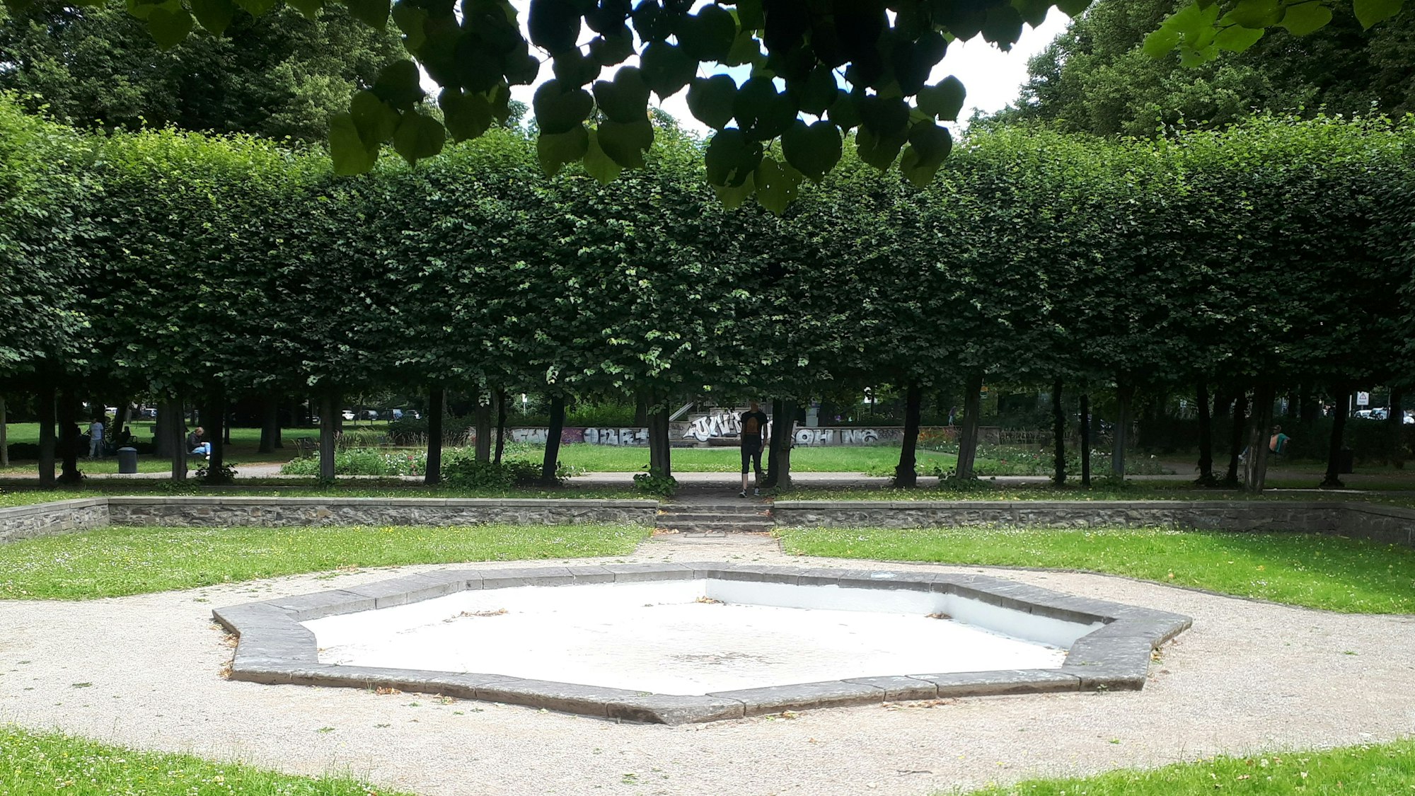 Das Brunnenbecken und die umlaufende Baumreihe an der Nippeser Alhambra.