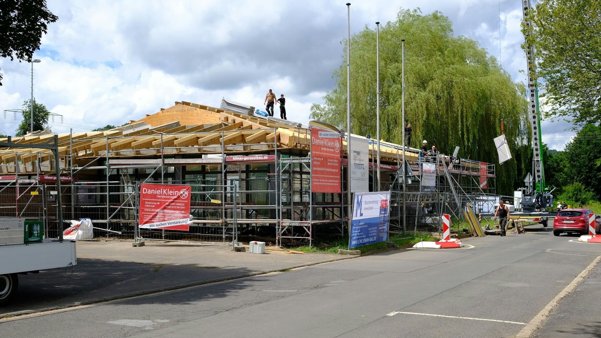 Bauhandwerker sind mit der Sanierung der Dachkonstruktion der Bürgerhalle in Kall beschäftigt.