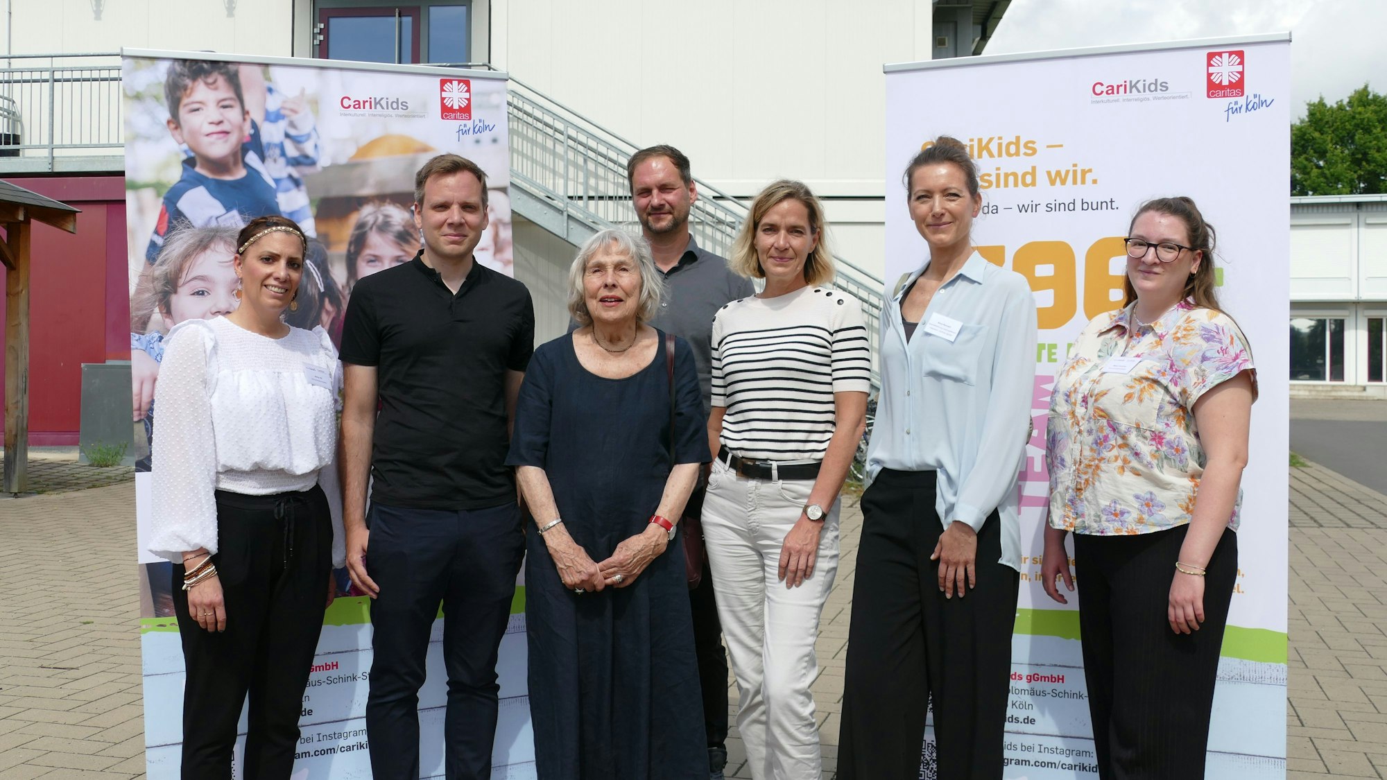 Menschen stehen vor Plakaten.