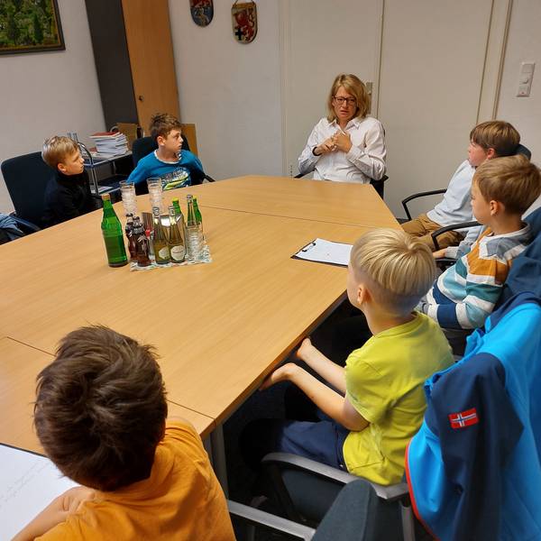 An einem großen Tisch sitzen mehrere Grundschulkinder mit der Bürgermeisterin Alexandra Gauß.