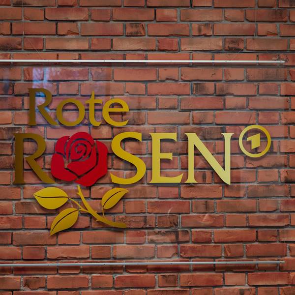 Das Logo der Telenovela "Rote Rosen" hängt im Studio an einer Wand.