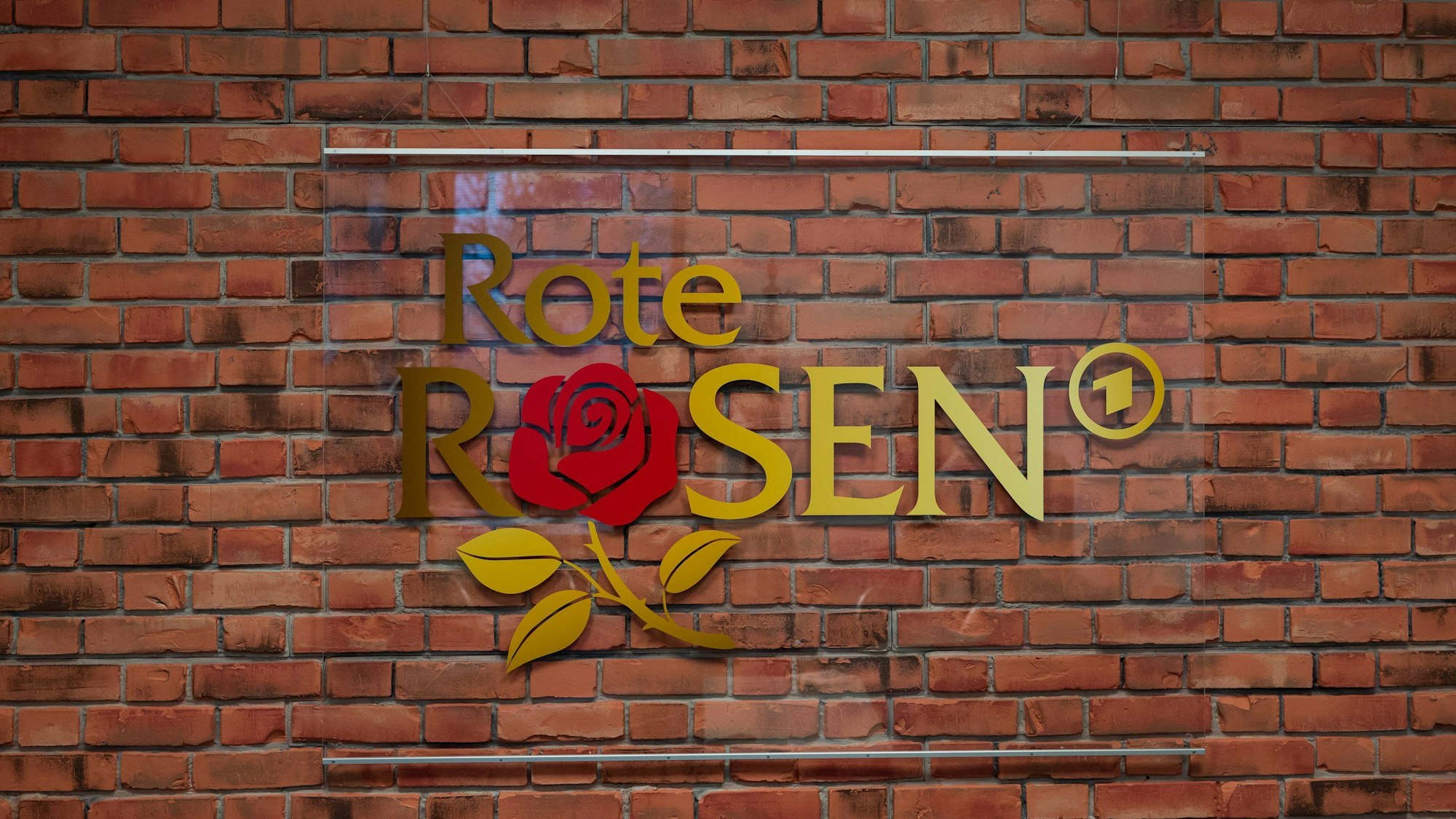 Das Logo der Telenovela "Rote Rosen" hängt im Studio an einer Wand.