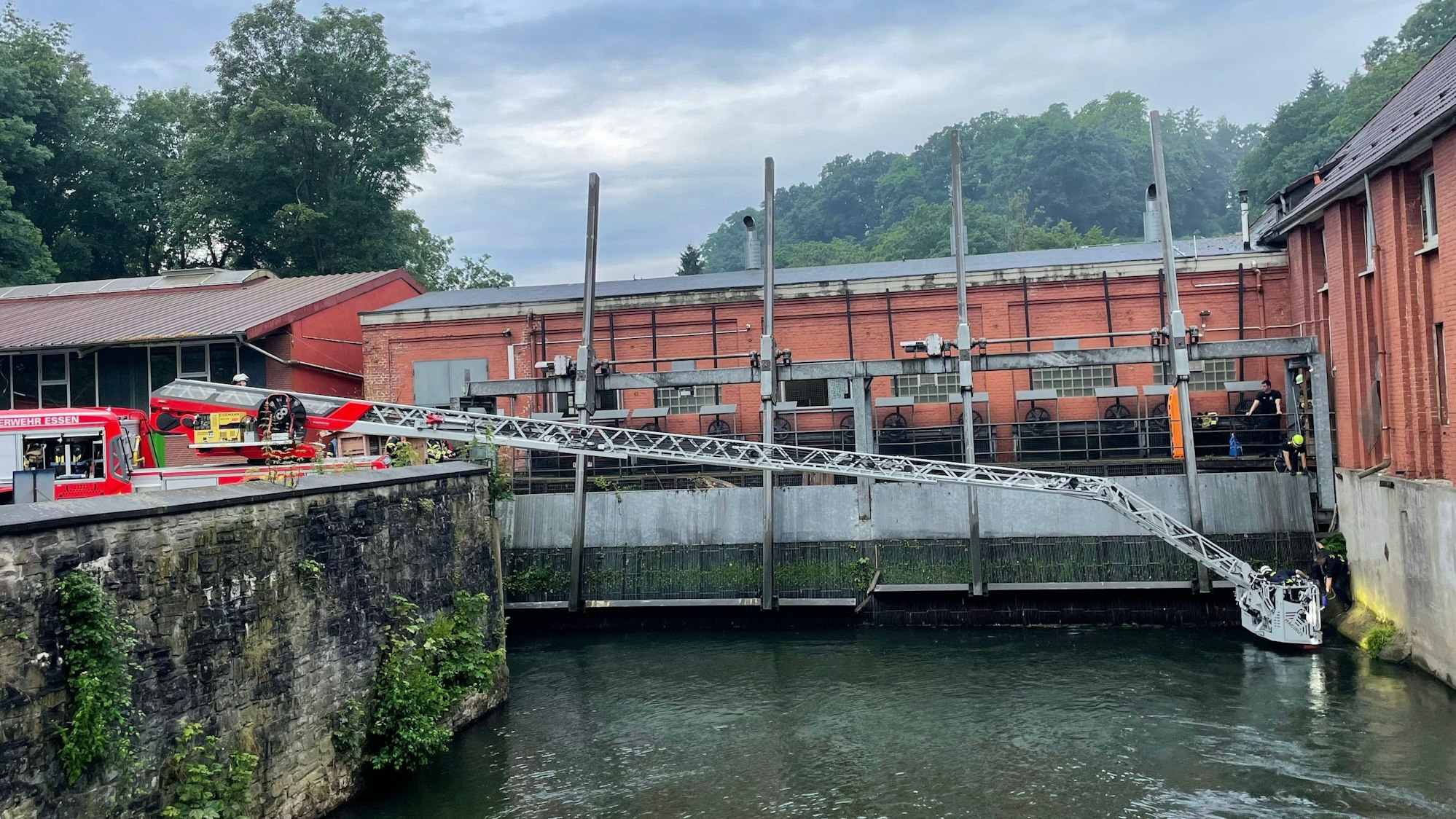 Einsatzkräfte retten mit einer Drehleiter eine Frau aus der Ruhr.