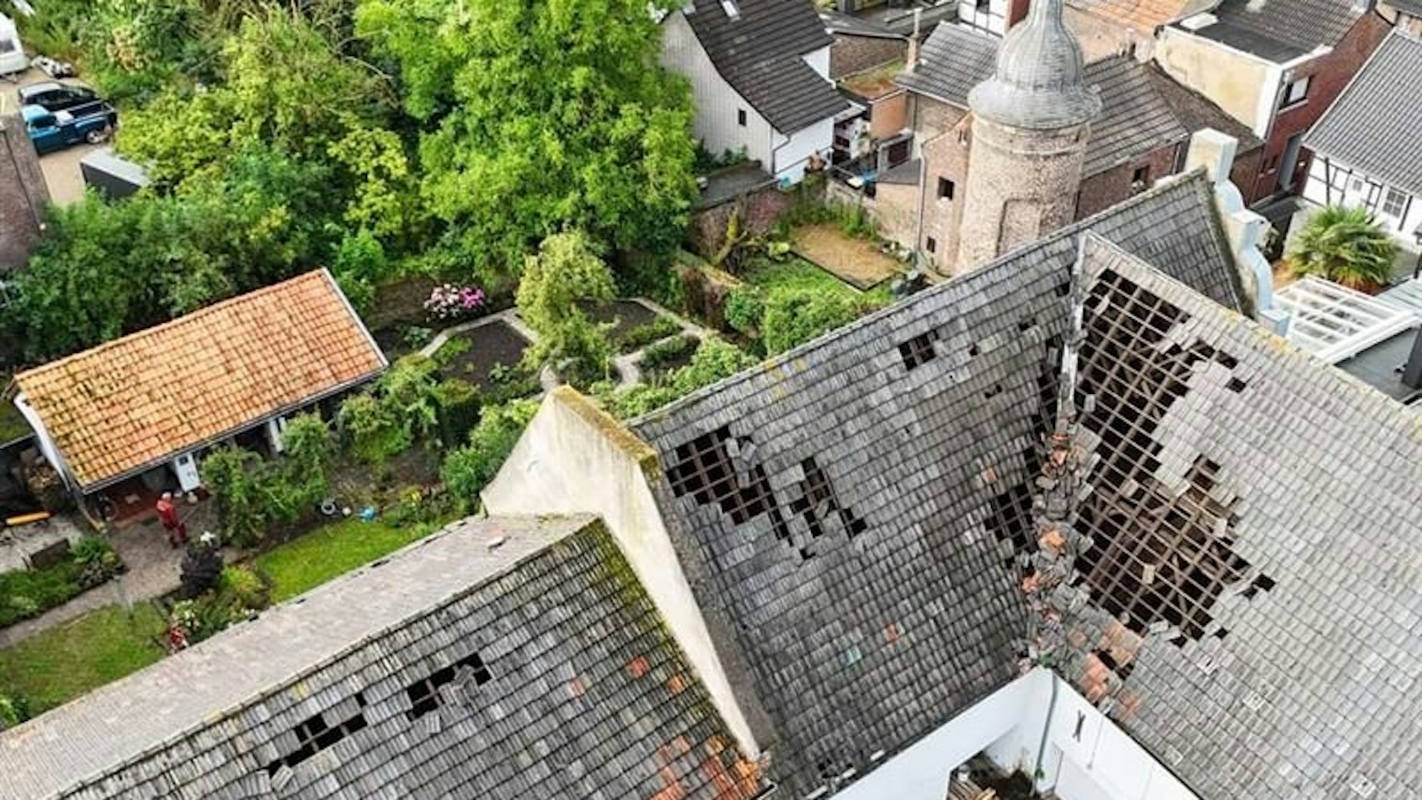Eine Windhose hat Alt-Kaster getroffen und schwere Schäden angerichtet. Das Luftbild zeigt abgedeckte Dächer im Burghof.