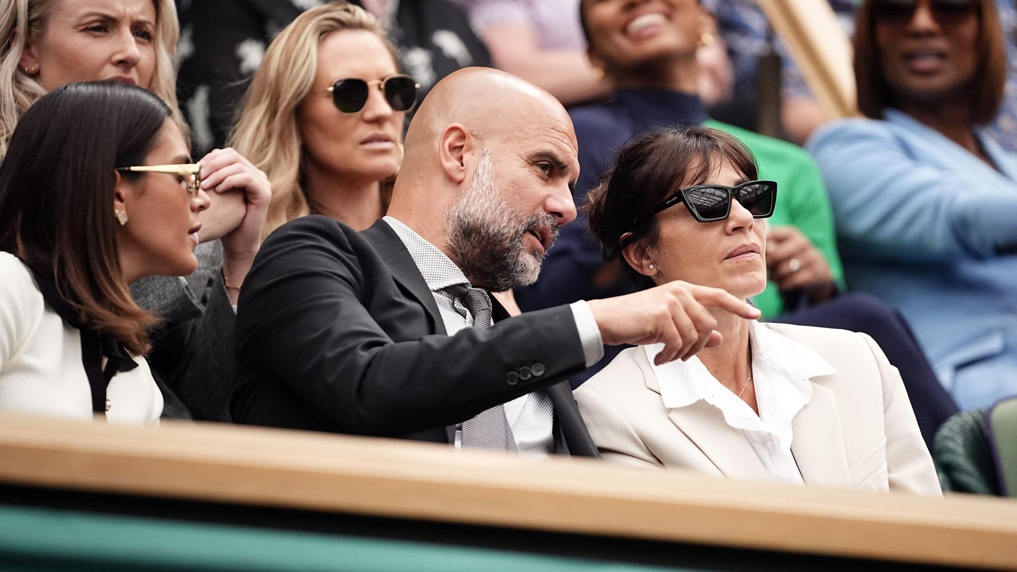Pep Guardiola sitzt mit seiner Frau Cristina (r) und seiner Tochter Maria (l) am sechsten Tag des Wimbledon-Turniers unter den Zuschauern.
