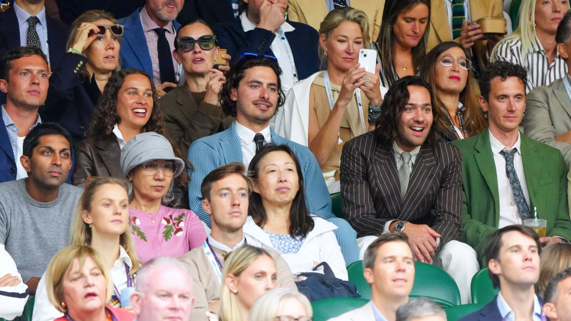 Im braunen Nadelstreifenanzug und bester Laune: Schauspieler Maxim Baldry verfolgt die Geschicke der Tennis-Profis auf dem Centre Court von Wimpledon.