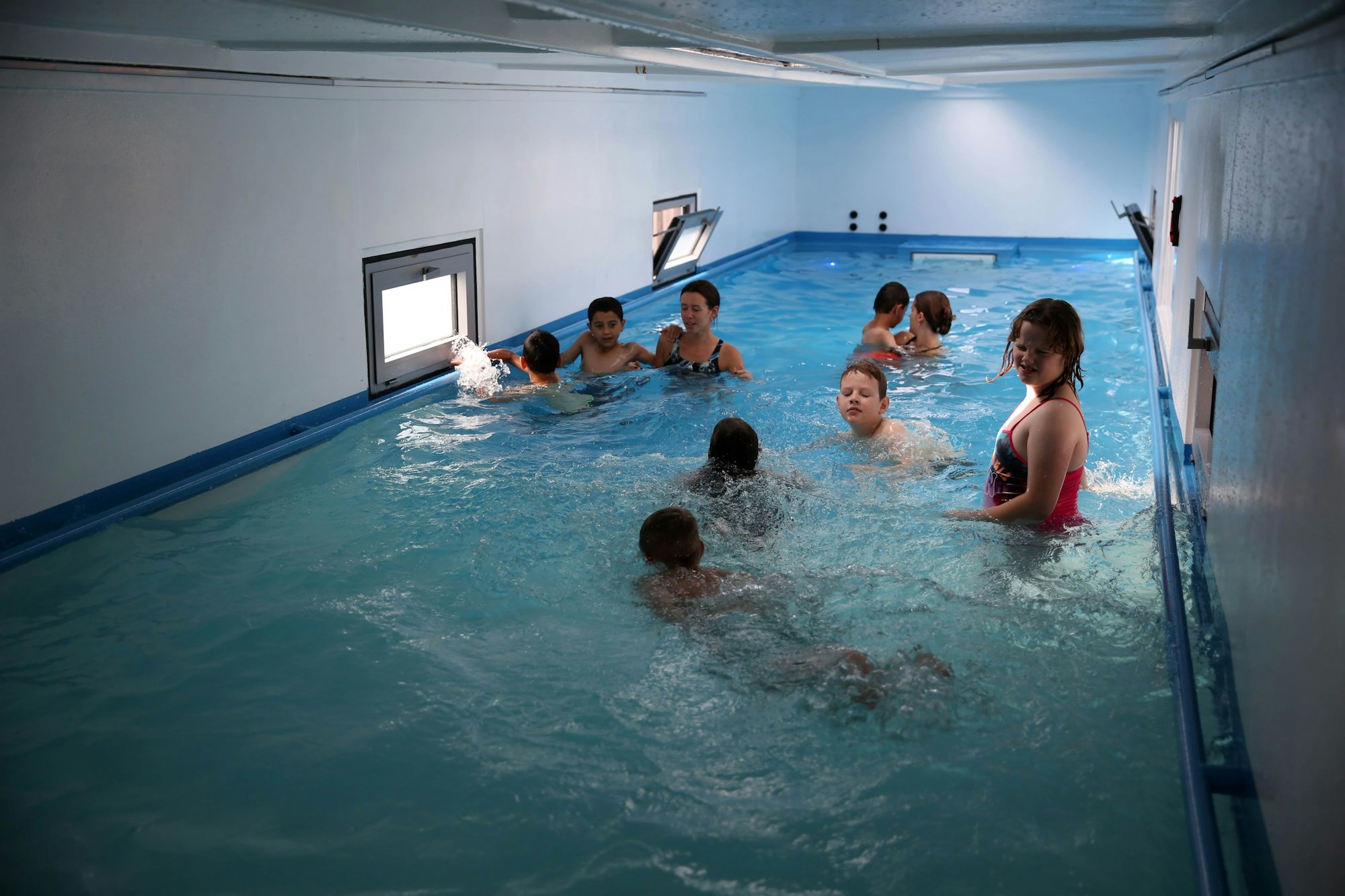 Kinder schwimmen in dem Container.