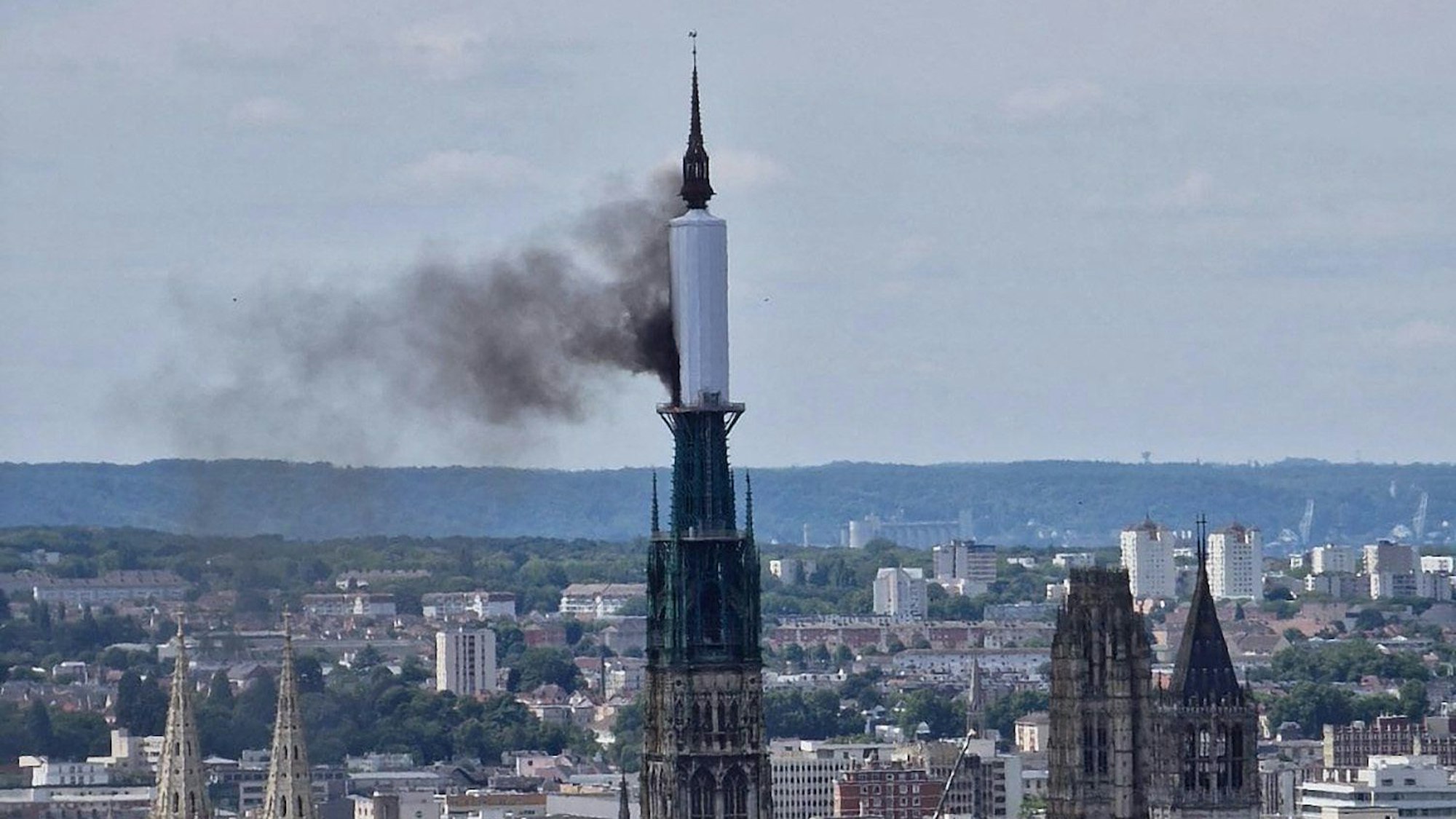 11.07.2024, Frankreich, Rouen: RECROP - Vom Turm der Kathedrale von Rouen steigt eine Rauchwolke auf. Der Bürgermeister von Rouen, Nicolas Mayer-Rossignol, sagte am Mittag auf X (ehemals Twitter), dass ein Feuer in der Kathedrale im Gange sei, und zeigte ein Foto, auf dem eine Rauchwolke von einem Gerüst um die Turmspitze aufstieg. Foto: Patrick Streiff/AFP/dpa +++ dpa-Bildfunk +++