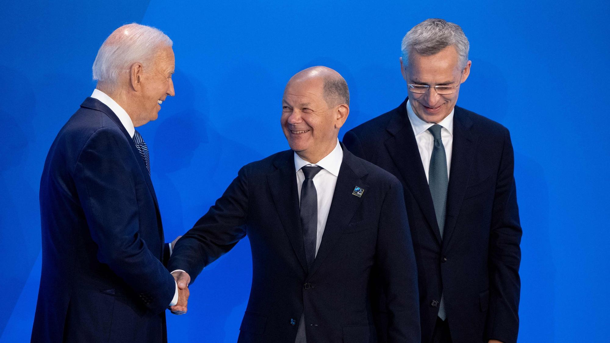 US-Präsident Joe Biden und NATO-Generalsekretär Jens Stoltenberg begrüßen den deutschen Bundeskanzler Olaf Scholz auf der Bühne vor einem Gruppenfoto während des NATO-Gipfels 2024 am 10. Juli 2024 in Washington, DC