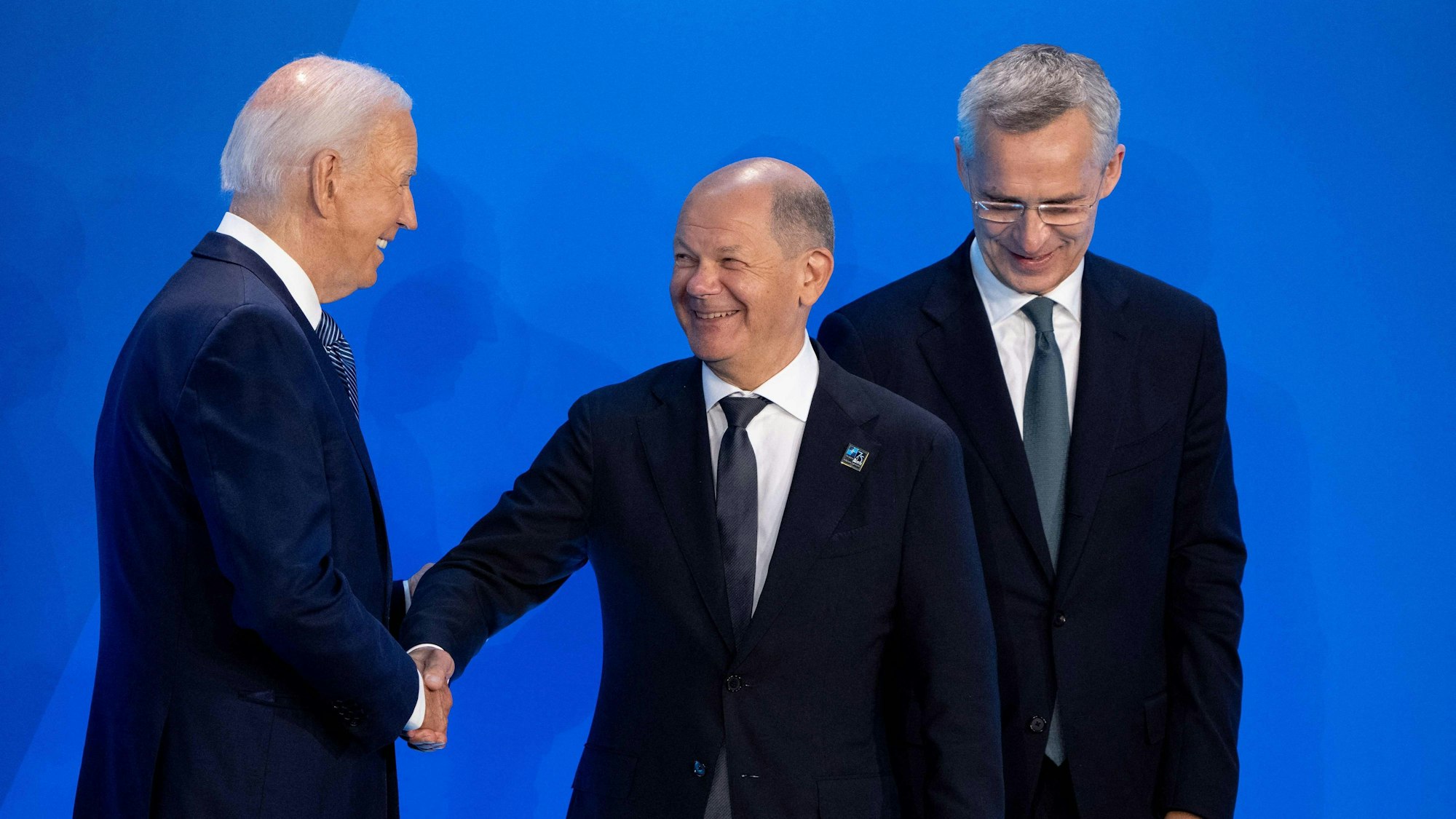 US-Präsident Joe Biden und NATO-Generalsekretär Jens Stoltenberg begrüßen den deutschen Bundeskanzler Olaf Scholz auf der Bühne vor einem Gruppenfoto während des NATO-Gipfels 2024 am 10. Juli 2024 in Washington, DC