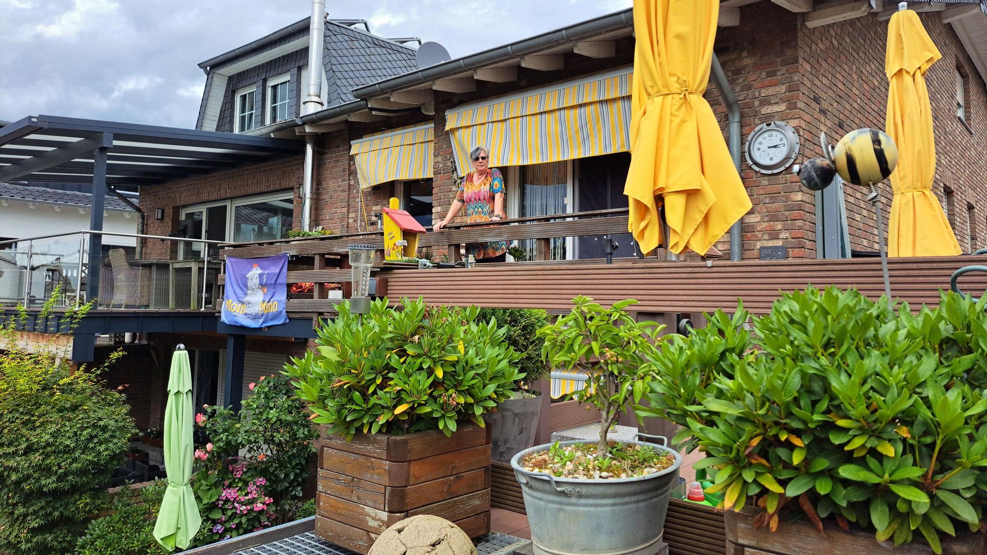 Von ihrem Balkon aus schaut Anne Bär in Richtung Erft. Am Geländer hing nach der Flut das Banner, mit dem gegen die weitere Nutzung der Kiesgrube protestiert wurde.