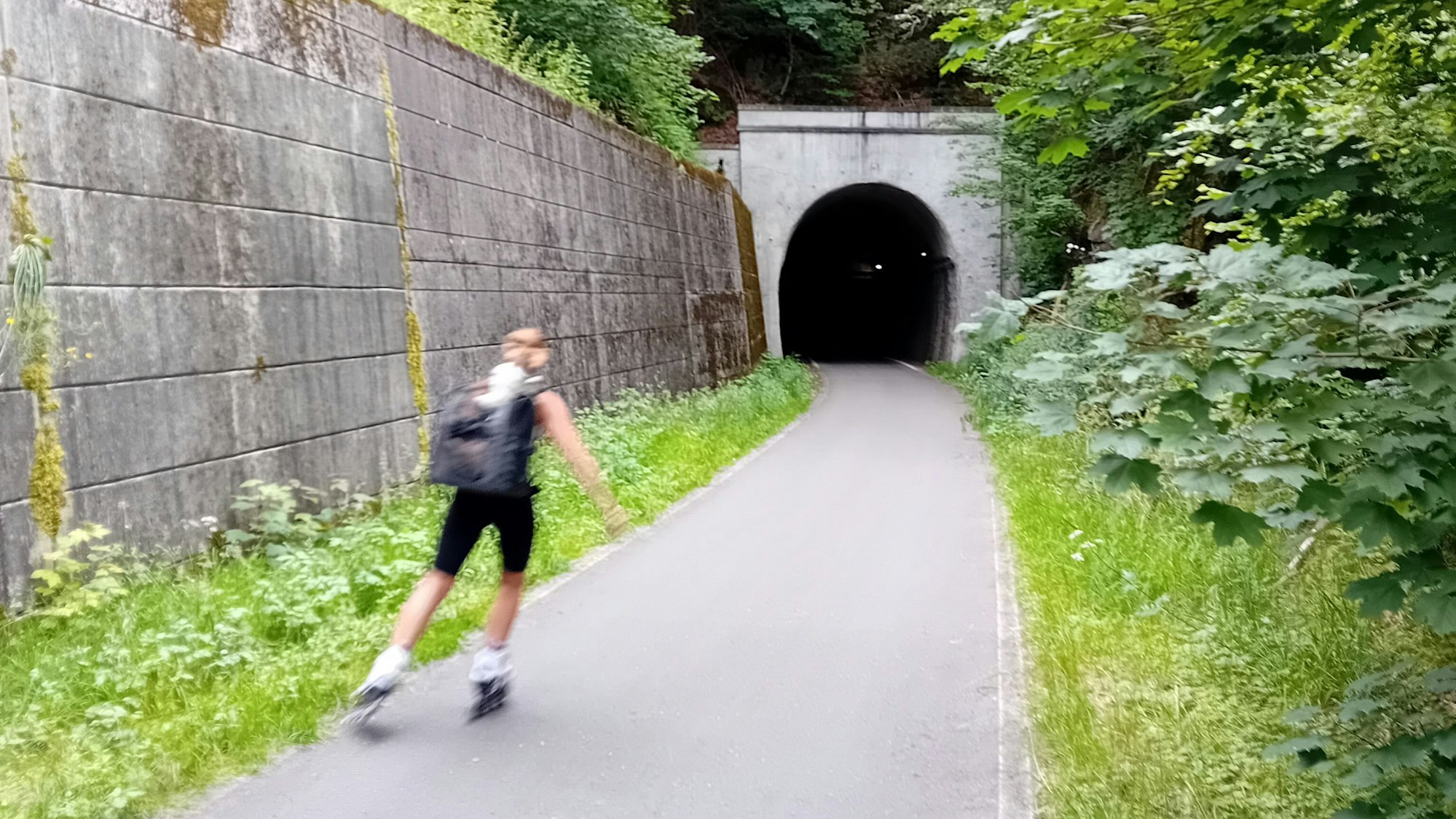 Eine Rollschuhläufer fährt in einen Tunnel ein.