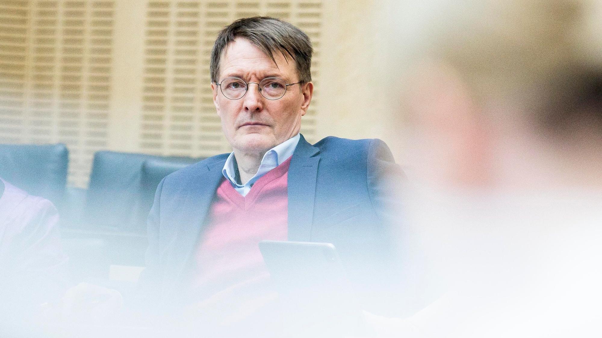 Bundesgesundheitsminister Karl Lauterbach (SPD) sitzt während eines Meetings an einem Tisch und blickt in die Kamera.
