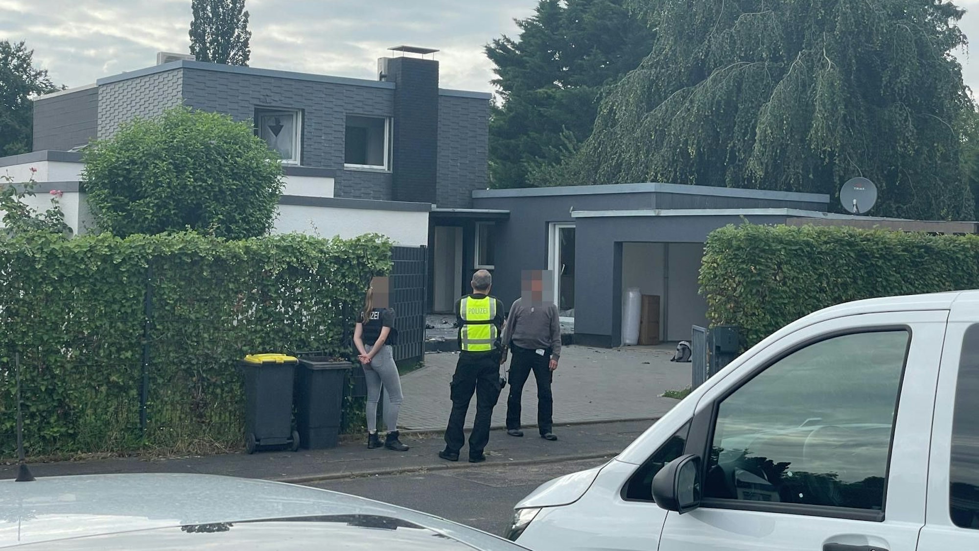 Einsatzkräfte stehen vor einem Haus in Rodenkirchen.