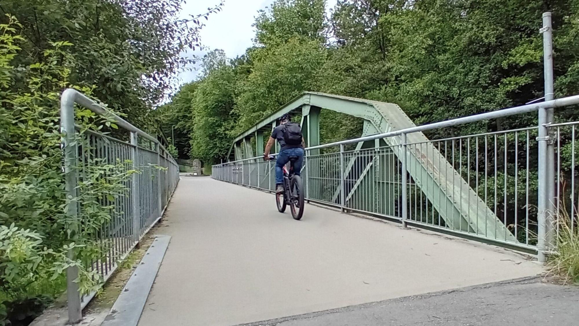 Ein Radfahrer auf einer Brücke.