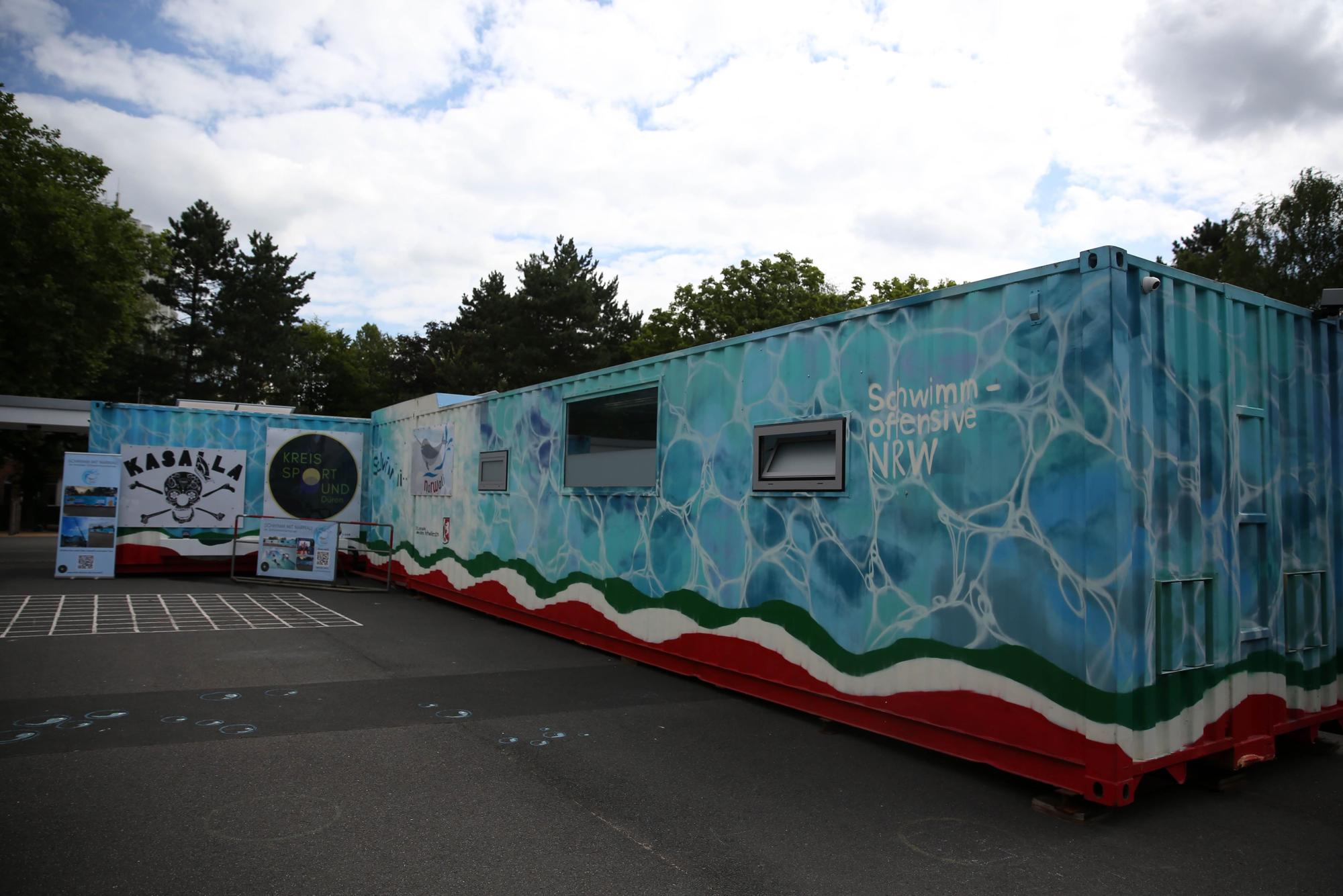 Ein Schwimmcontainer steht auf einem Platz.